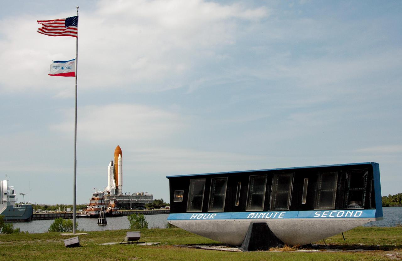 KENNEDY SPACE CENTER, FLA. - Rolling back from Launch Pad 39B, Space Shuttle Discovery, atop a Mobile Launcher Platform, makes its way slowly toward the Vehicle Assembly Building (VAB) at NASA’s Kennedy Space Center. The view is across the Turn Basin from an area near the NASA News Center. In the foreground is the mission countdown clock that tracks the time from before launch to landing.Once inside the VAB, Discovery will be demated from its External Tank and lifted into the transfer aisle. On or about June 7, Discovery will be lifted and attached to its new tank and Solid Rocket Boosters, which are already in the VAB. Only the 15th rollback in Space Shuttle Program history, the 4.2-mile journey allows additional modifications to be made to the External Tank prior to a safe Return to Flight. Discovery is expected to be rolled back to the launch pad in mid-June for Return to Flight mission STS-114. The launch window extends from July 13 to July 31.