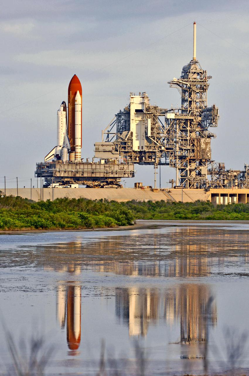 KENNEDY SPACE CENTER, FLA.  -  At NASA’s Kennedy Space Center, Space Shuttle Discovery, resting on the Mobile Launcher Platform, rolls away from Launch Pad 39B via the Crawler_Transporter underneath.  At right are the Rotating and Fixed Service Structures (RSS and FSS).  Atop the FSS is the 80-foot lightning mast. Discovery is returning to the Vehicle Assembly Building (VAB) where it will be demated from its External Tank and lifted into the transfer aisle.  On or about June 7, Discovery will be attached to its new tank and Solid Rocket Boosters, which are already in the VAB.  Only the 15th rollback in Space Shuttle Program history, the 4.2-mile journey allows additional modifications to be made to the External Tank prior to a safe Return to Flight.  Discovery is expected to be rolled back to the launch pad in mid-June for Return to Flight mission STS-114.  The launch window extends from July 13 to July 31. [Photo courtesy of Scott Andrews]