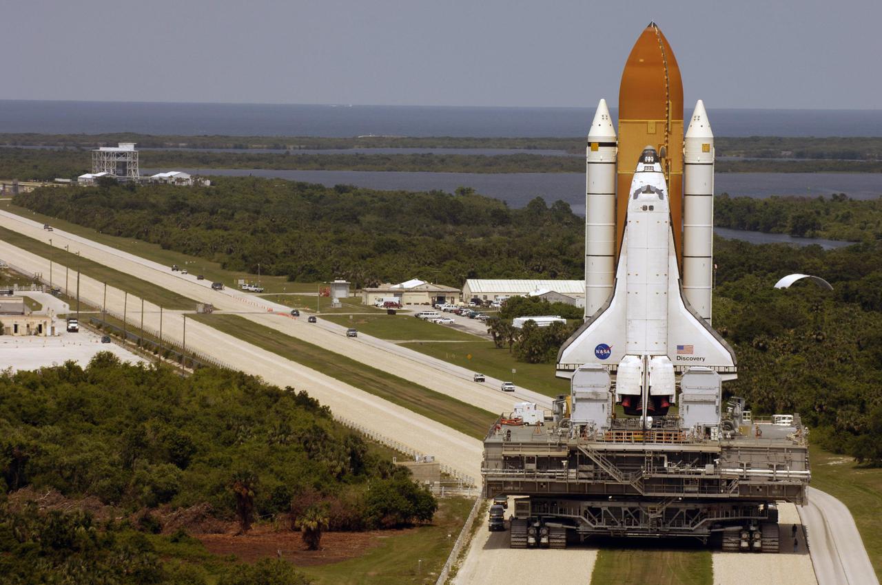 KENNEDY SPACE CENTER, FLA.  -  Space Shuttle Discovery, resting on the Mobile Launcher Platform, turns the corner on the crawlerway as it rolls back from Launch Pad 39B to the Vehicle Assembly Building (VAB) at NASA’s Kennedy Space Center.  Once inside the VAB, it will be demated from its External Tank and lifted into the transfer aisle.  On or about June 7, Discovery will be attached to its new tank and Solid Rocket Boosters, which are already in the VAB.  Only the 15th rollback in Space Shuttle Program history, the 4.2-mile journey allows additional modifications to be made to the External Tank prior to a safe Return to Flight.  Discovery is expected to be rolled back to the launch pad in mid-June for Return to Flight mission STS-114.  The launch window extends from July 13 to July 31. [Photo courtesy of Scott Andrews]