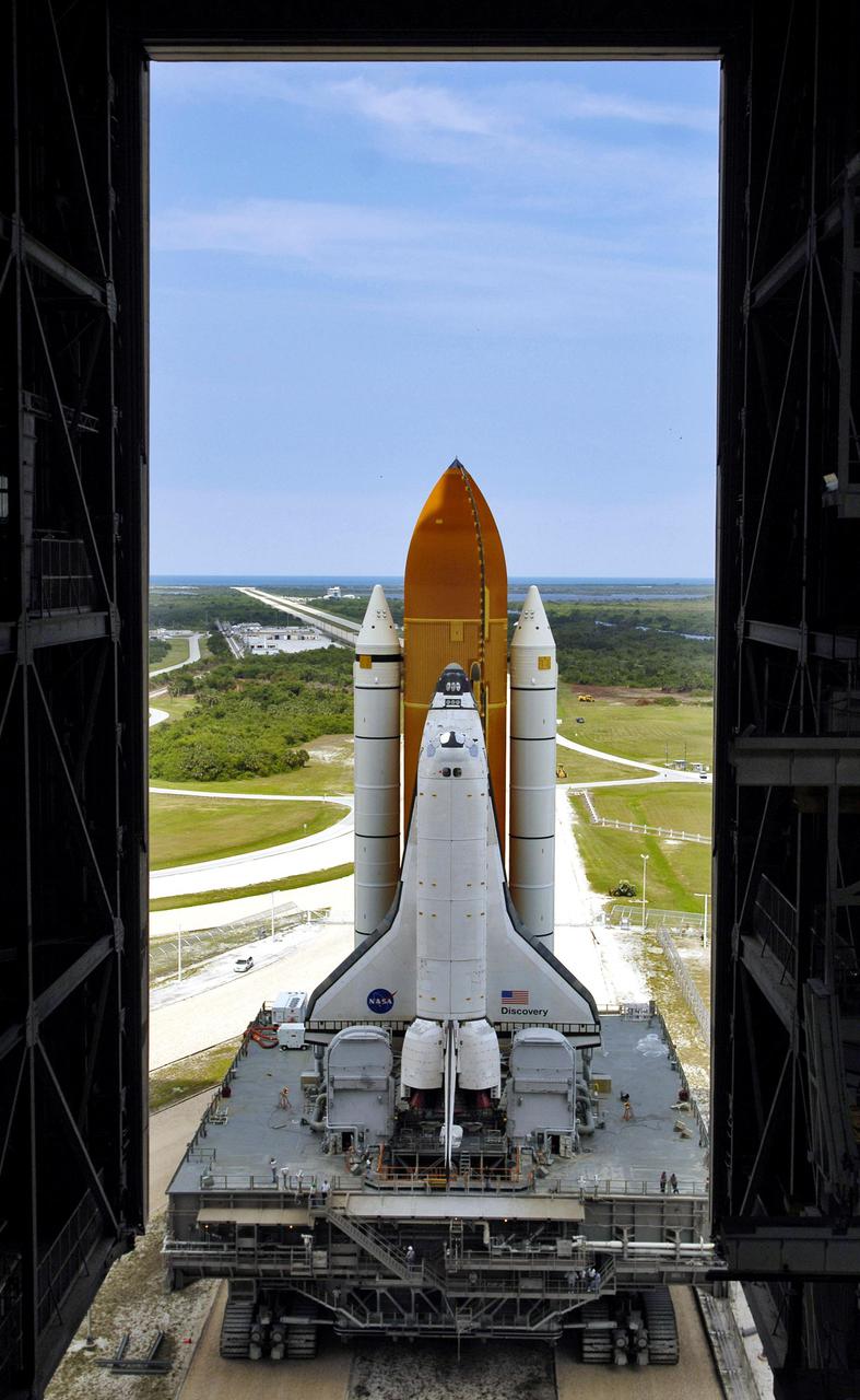 KENNEDY SPACE CENTER, FLA.  -  At NASA’s Kennedy Space Center, Space Shuttle Discovery, resting on the Mobile Launcher Platform, rolls into high bay 1 of the Vehicle Assembly Building (VAB).  The Shuttle is being rolled back from Launch Pad 39B. It will be demated from its External Tank and lifted into the transfer aisle.  On or about June 7, Discovery will be attached to its new tank and Solid Rocket Boosters, which are already in the VAB.  Only the 15th rollback in Space Shuttle Program history, the 4.2-mile journey allows additional modifications to be made to the External Tank prior to a safe Return to Flight.  Discovery is expected to be rolled back to the launch pad in mid-June for Return to Flight mission STS-114.  The launch window extends from July 13 to July 31. [Photo courtesy of Scott Andrews]