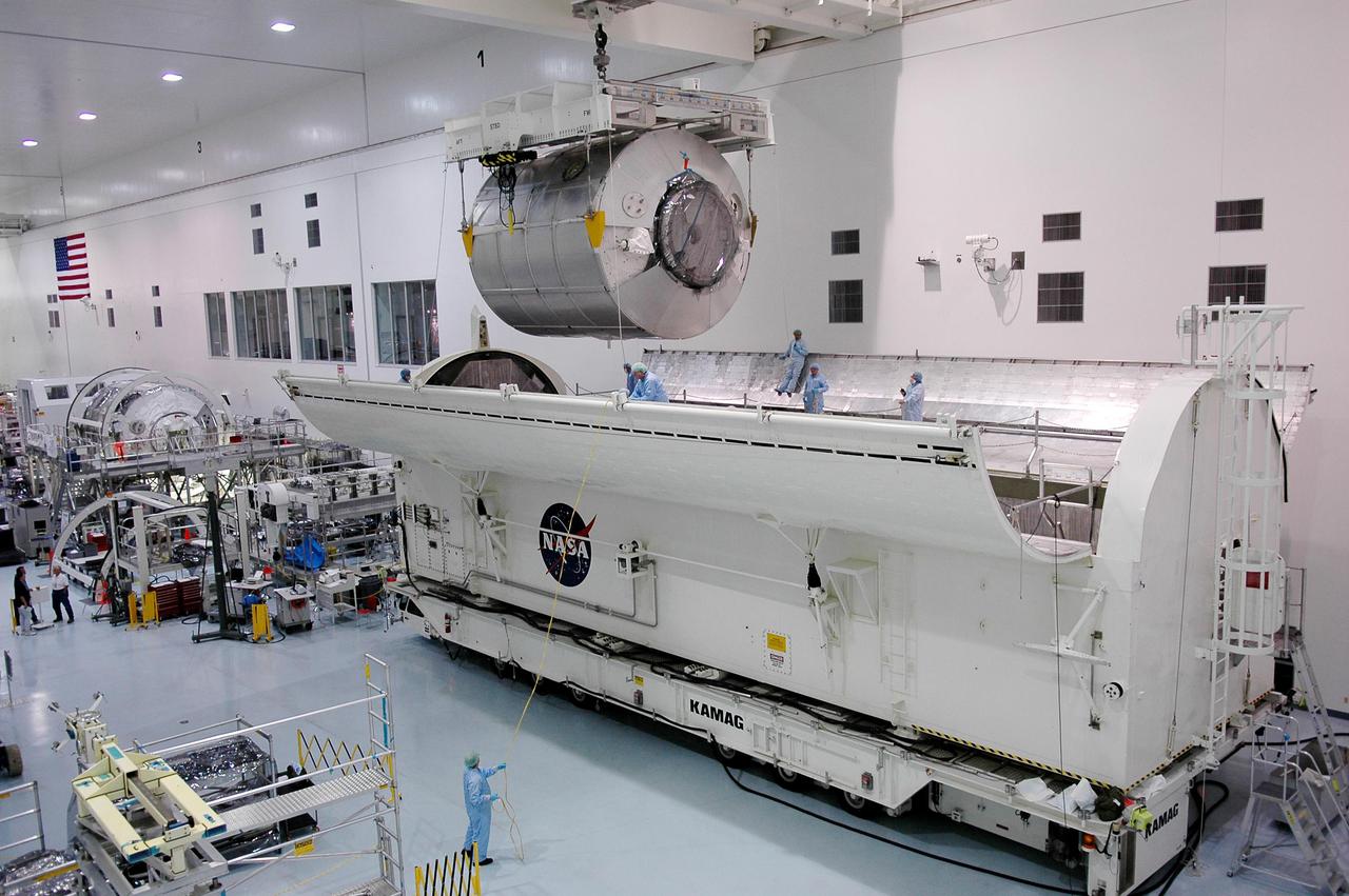 KENNEDY SPACE CENTER, FLA. - In the Space Station Processing Facility at NASA’s Kennedy Space Center, the Multi-Purpose Logistics Module Raffaello is lifted out of the Payload Transportation Canister where it was waiting transfer to the pad. The module is being moved back to its work stand to allow the processing team access in order to address concerns with mechanical fasteners inside the module that do not incorporate an adequate secondary locking feature. The assessment and additional work is being conducted to ensure that the fasteners do not disengage during ascent. Raffaello is scheduled to launch on Discovery's Return to Flight mission STS-114.