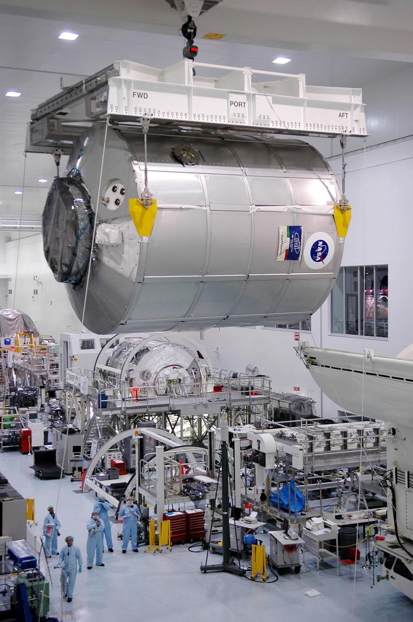 KENNEDY SPACE CENTER, FLA. - In the Space Station Processing Facility at NASA’s Kennedy Space Center, the Multi-Purpose Logistics Module Raffaello is moved away from the Payload Transportation Canister at right where it was waiting transfer to the pad. The module is being moved back to its work stand to allow the processing team access in order to address concerns with mechanical fasteners inside the module that do not incorporate an adequate secondary locking feature. The assessment and additional work is being conducted to ensure that the fasteners do not disengage during ascent. Raffaello is scheduled to launch on Discovery's Return to Flight mission STS-114.