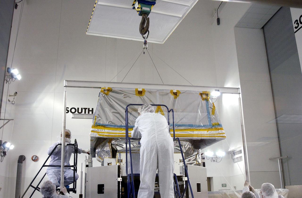 KENNEDY SPACE CENTER, FLA. - In the Astrotech Payload Processing Facility at Vandenberg Air Force Base, workers from NASA’s Jet Propulsion Laboratory in California and Ball Aerospace from Boulder, Colo., help guide a “hat” into place on the CloudSat spacecraft before conducting the Cloud Profiling Radar (CPR) functional tests. The hat is used to absorb the RF radiation that is emitted by the instrument during the test. CloudSat will fly in combination with the Cloud-Aerosol Lidar and Infrared Pathfinder Satellite Observation (CALIPSO) to provide never-before-seen 3-D perspectives of how clouds and aerosols form, evolve, and affect weather and climate. CALIPSO and CloudSat will join three other satellites to enhance understanding of climate systems. The launch date for CALIPSO_ CloudSat is no earlier than Aug. 22.
