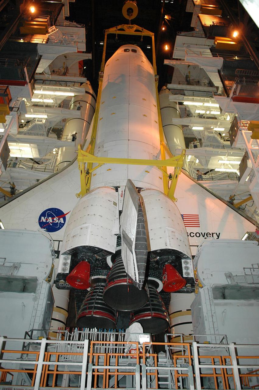 KENNEDY SPACE CENTER, FLA.  - In high bay 1 of the Vehicle Assembly Building at NASA’s Kennedy Space Center, the orbiter Discovery is being lifted away from the External Tank and Solid Rocket Boosters (behind the orbiter).  After demating from its External Tank (ET), the orbiter will be placed on a transporter in the transfer aisle and moved to high bay 3 for remating with another tank, ET-121.  Discovery is expected to be rolled back to the launch pad in mid-June for Return to Flight mission STS-114.  The launch window extends from July 13 to July 31.
