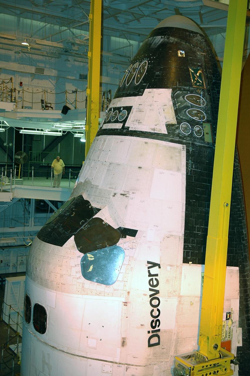 KENNEDY SPACE CENTER, FLA.  - In high bay 1 of the Vehicle Assembly Building at NASA’s Kennedy Space Center, a worker on an upper level watches as orbiter Discovery is lifted by crane away from the External Tank and Solid Rocket Boosters.   After demating from its External Tank (ET), the orbiter will be placed on a transporter in the transfer aisle and moved to high bay 3 for remating with another tank, ET-121.  Discovery is expected to be rolled back to the launch pad in mid-June for Return to Flight mission STS-114.  The launch window extends from July 13 to July 31.