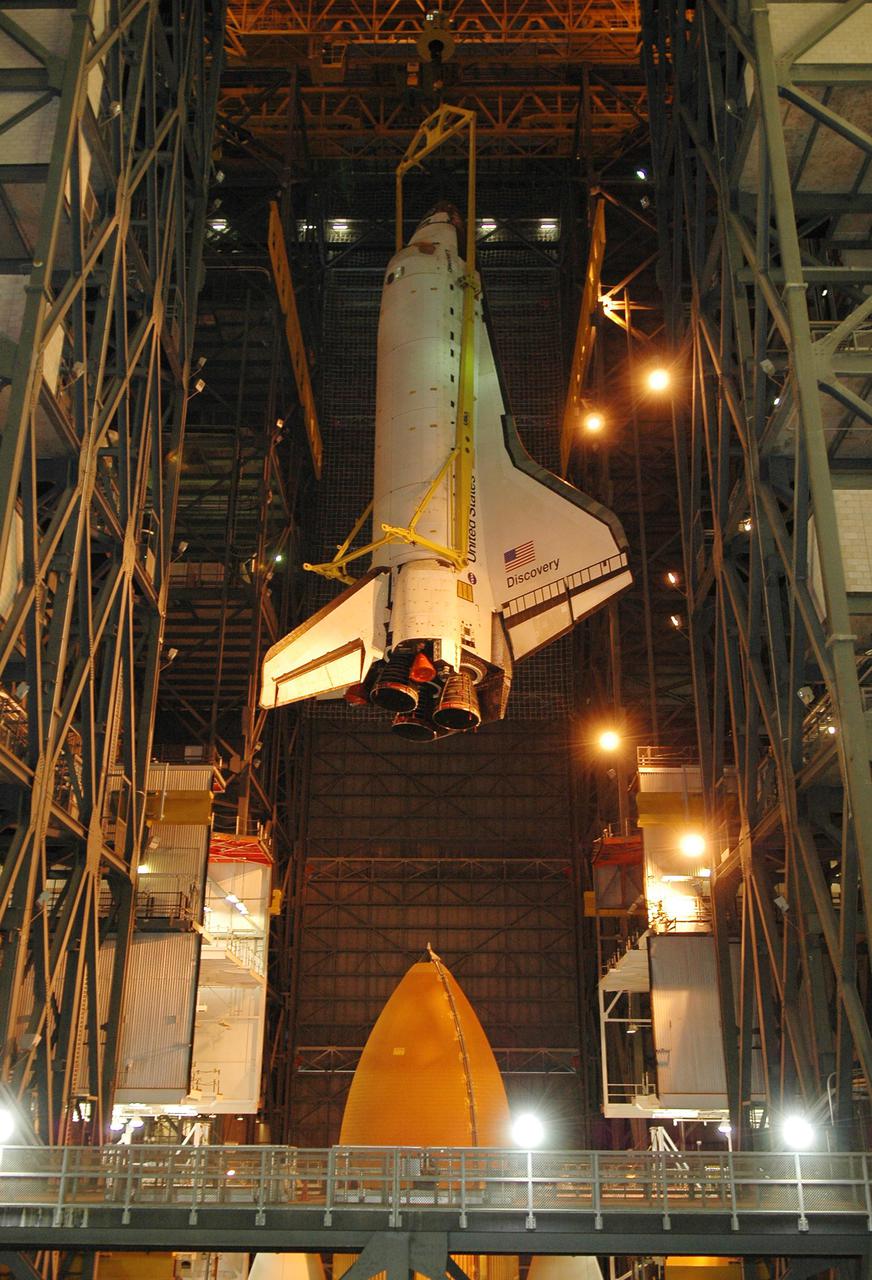 KENNEDY SPACE CENTER, FLA.  - In high bay 1 of the Vehicle Assembly Building at NASA’s Kennedy Space Center, the 122-foot-long orbiter Discovery is suspended in mid-air after being lifted away from the 154-foot-high External Tank (below) and Solid Rocket Boosters. After demating from its External Tank (ET), the orbiter will be placed on a transporter in the transfer aisle and moved to high bay 3 for remating with another tank, ET-121.  Discovery is expected to be rolled back to the launch pad in mid-June for Return to Flight mission STS-114.  The launch window extends from July 13 to July 31.