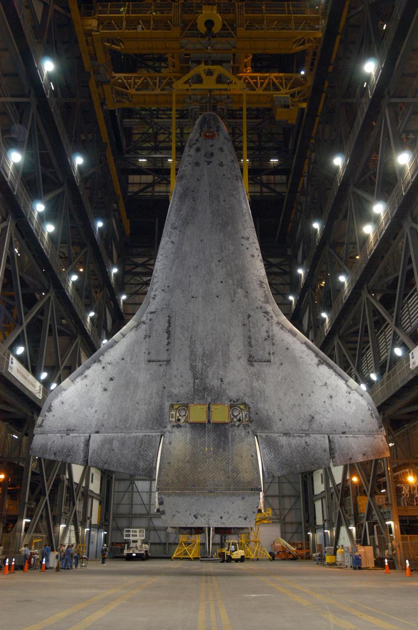 KENNEDY SPACE CENTER, FLA. - In the transfer aisle of the Vehicle Assembly Building, orbiter Discovery is raised to a vertical position. It will be lifted over a cross-beam into high bay 3 and remated with the new External Tank, ET-121, and Solid Rocket Boosters in the bay. That tank was originally scheduled to fly with Atlantis on the second Return to Flight mission, STS-121. A new heater was added to the tank's feedline bellows, part of the pipeline that carries the liquid oxygen to the orbiter’s main engines, to minimize the potential for ice and frost buildup. After the remate, technicians will work final closeouts on the fully assembled Space Shuttle stack, and perform liquid oxygen and liquid hydrogen electrical mates and an interface verification test. Discovery is currently scheduled to return to Launch Pad 39B on June 13.
