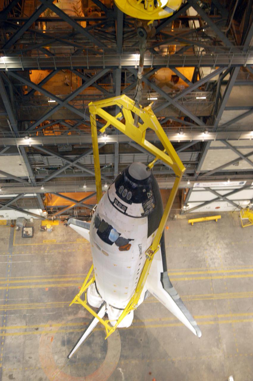 KENNEDY SPACE CENTER, FLA. - The orbiter Discovery hangs suspended above the floor of the transfer aisle in the Vehicle Assembly Building. It will be lifted over a cross-beam into high bay 3 and remated with the new External Tank, ET-121, and Solid Rocket Boosters in the bay. That tank was originally scheduled to fly with Atlantis on the second Return to Flight mission, STS-121. A new heater was added to the tank's feedline bellows, part of the pipeline that carries the liquid oxygen to the orbiter’s main engines, to minimize the potential for ice and frost buildup. After the remate, technicians will work final closeouts on the fully assembled Space Shuttle stack, and perform liquid oxygen and liquid hydrogen electrical mates and an interface verification test. Discovery is currently scheduled to return to Launch Pad 39B on June 13.