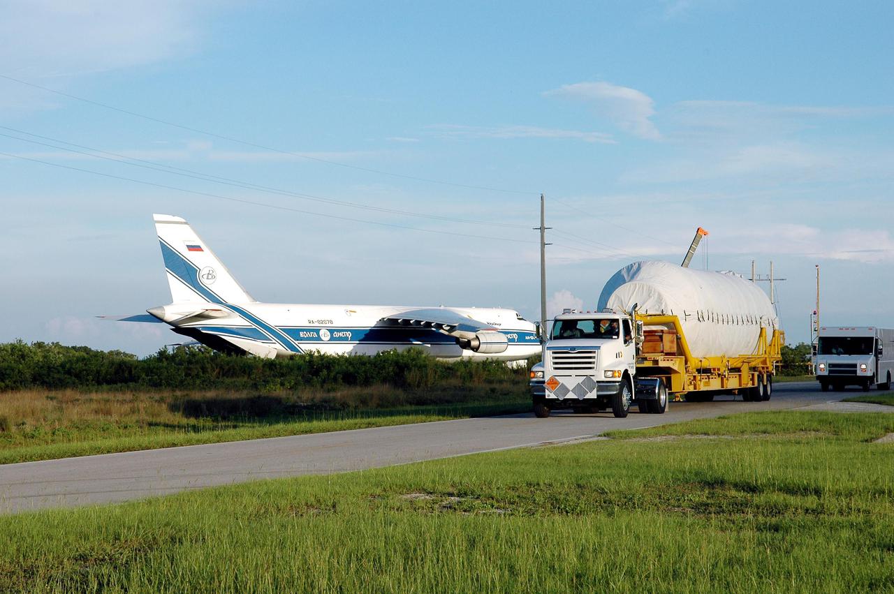 KENNEDY SPACE CENTER, FLA.  -  Safely placed on a flat bed truck, the Centaur (Block I) is rolled away from Cape Canaveral Air Force Station Skid Strip where it landed aboard a Russian Antonov AH-124-100 cargo airplane, seen at left.  The upper stage Centaur will be mated with the Lockheed Martin Atlas V, designated AV-007, that is the launch vehicle for the Mars Reconnaissance Orbiter (MRO). The MRO is designed for a series of global mapping, regional survey and targeted observations from a near-polar, low-altitude Mars orbit. These observations will be unprecedented in terms of the spatial resolution and coverage achieved by the orbiter’s instruments as they observe the atmosphere and surface of Mars while probing its shallow subsurface as part of a “follow the water” strategy.  The orbiter is undergoing environmental tests in facilities at Lockheed Martin Space Systems in Denver, Colo., and is on schedule for a launch window that begins Aug. 10. Launch will be from Launch Complex 41 at Cape Canaveral Air Force Station in Florida.