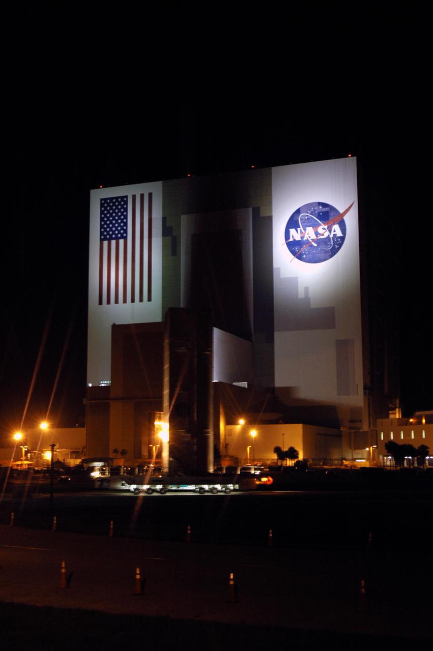 KENNEDY SPACE CENTER, FLA.  -  In the dark before dawn, the payloads that will launch aboard Space Shuttle Discovery's Return to Flight mission STS-114  roll past the Vehicle Assembly Building at NASA’s Kennedy Space Center.  Enclosed in a payload canister, the payloads are heading for Launch Pad 39B. The canister will be lifted up alongside the Rotating Service Structure to the Payload Changeout Room where the STS-114 payloads will be removed.  Discovery’s payloads include the Multi-Purpose Logistics Module Raffaello, the Lightweight Multi-Purpose Experiment Support Structure Carrier (LMC), and the External Stowage Platform-2 (ESP-2).  Raffaello will deliver supplies to the International Space Station including food, clothing and research equipment.  The LMC will carry a replacement Control Moment Gyroscope and a tile repair sample box.  The ESP-2 is outfitted with replacement parts.  Discovery’s launch window extends from July 13 through July 31.