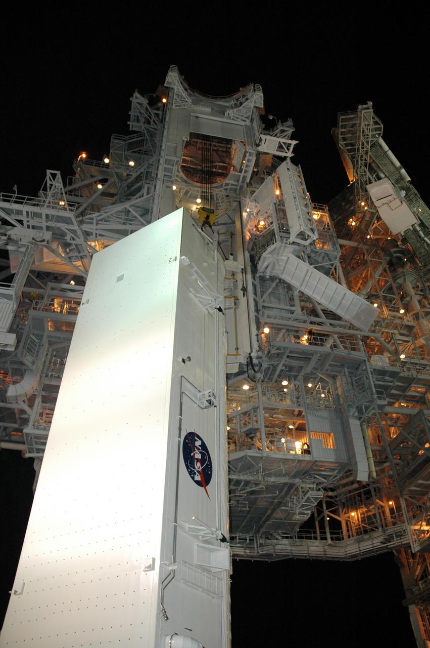 KENNEDY SPACE CENTER, FLA.  -  On Launch Pad 39B, lights on the Rotating Service Structure brighten the night as the payload canister carrying payloads that will launch aboard Space Shuttle Discovery's Return to Flight mission STS-114 is moved into position.  The canister will be lifted up to the Payload Changeout Room where the STS-114 payloads will be removed.  Discovery’s payloads include the Multi-Purpose Logistics Module Raffaello, the Lightweight Multi-Purpose Experiment Support Structure Carrier (LMC), and the External Stowage Platform-2 (ESP-2).  Raffaello will deliver supplies to the International Space Station including food, clothing and research equipment.  The LMC will carry a replacement Control Moment Gyroscope and a tile repair sample box.  The ESP-2 is outfitted with replacement parts.  Discovery’s launch window extends from July 13 through July 31.