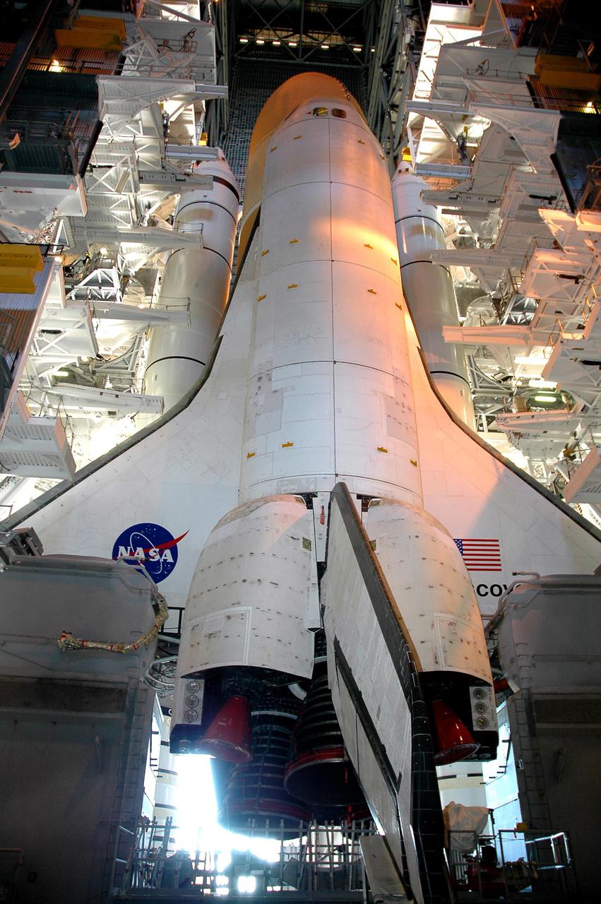 KENNEDY SPACE CENTER, FLA.  -  Framed in lights both inside and from outside, Space Shuttle Discovery waits on top of the Mobile Launcher Platform in the Vehicle Assembly Building for rollout to Launch Pad 39B.  Rollout is expected to begin about 12:01 a.m. June 15 for the 4-mile, 6-hour trip to the pad. On either side of Discovery’s tail and orbital maneuvering system pods are the Tail Masts that support the fluid, gas and electrical requirements of the orbiter’s liquid oxygen and liquid hydrogen aft T-0 umbilicals. Space Shuttle Discovery's Return to Flight mission STS-114 is scheduled for liftoff in a window extending from July 13 to July 31.