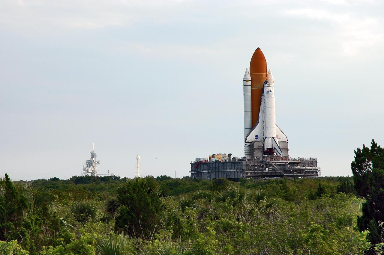KENNEDY SPACE CENTER, FLA. - Space Shuttle Discovery makes its way along the crawlerway to Launch Pad 39B, seen at left. First motion for the 4-mile, 6-hour journey was at 1:58 a.m. EDT. The Space Shuttle rests on a Mobile Launcher Platform that sits atop a Crawler-Transporter. This is the second rollout of Discovery after being returned to the Vehicle Assembly Building for connection to an improved External Tank. Launch of Discovery on its Return to Flight mission STS-114 is targeted for a launch window extending from July 13 to July 31.