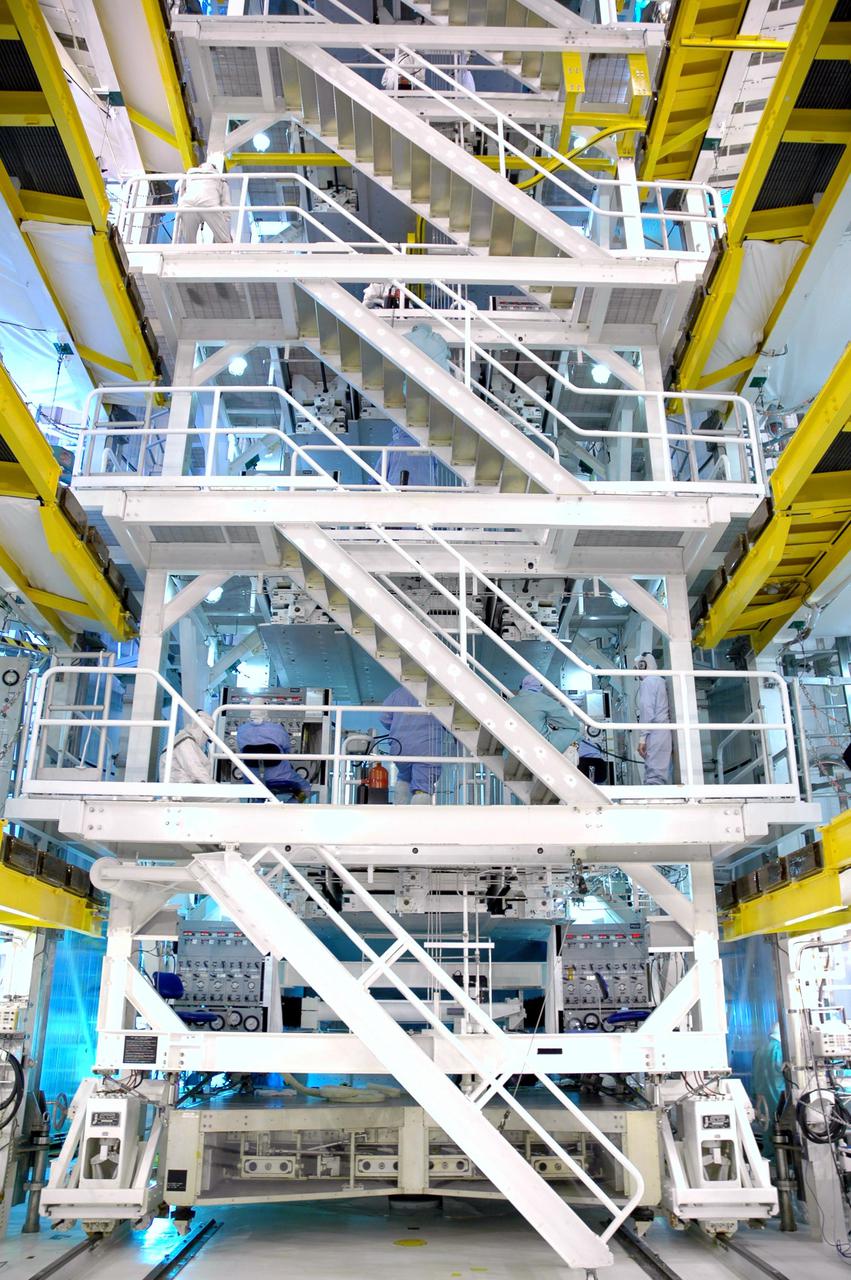 KENNEDY SPACE CENTER, FLA. - In the Payload Changeout Room on Launch Pad 39B, access stairs are rolled into place next to the Payload Ground Handling Mechanism, which is used to transfer the payloads into the orbiter. The payloads for Return to Flight mission STS-114 that are being transferred to Discovery’s payload bay include a Control Moment Gyro, the Thermal Protection System Detailed Test Objective box, which is placed on the Lightweight Multi-Purpose Experiment Support Structure Carrier, External Stowage Platform 2 and Multi-Purpose Logistics Module Raffaello. Already installed in the payload bay are the airlock, the Canadarm 2, or Shuttle arm, and the Orbiter Boom Sensor System. The launch window for mission STS-114 extends from July 13 to July 31.