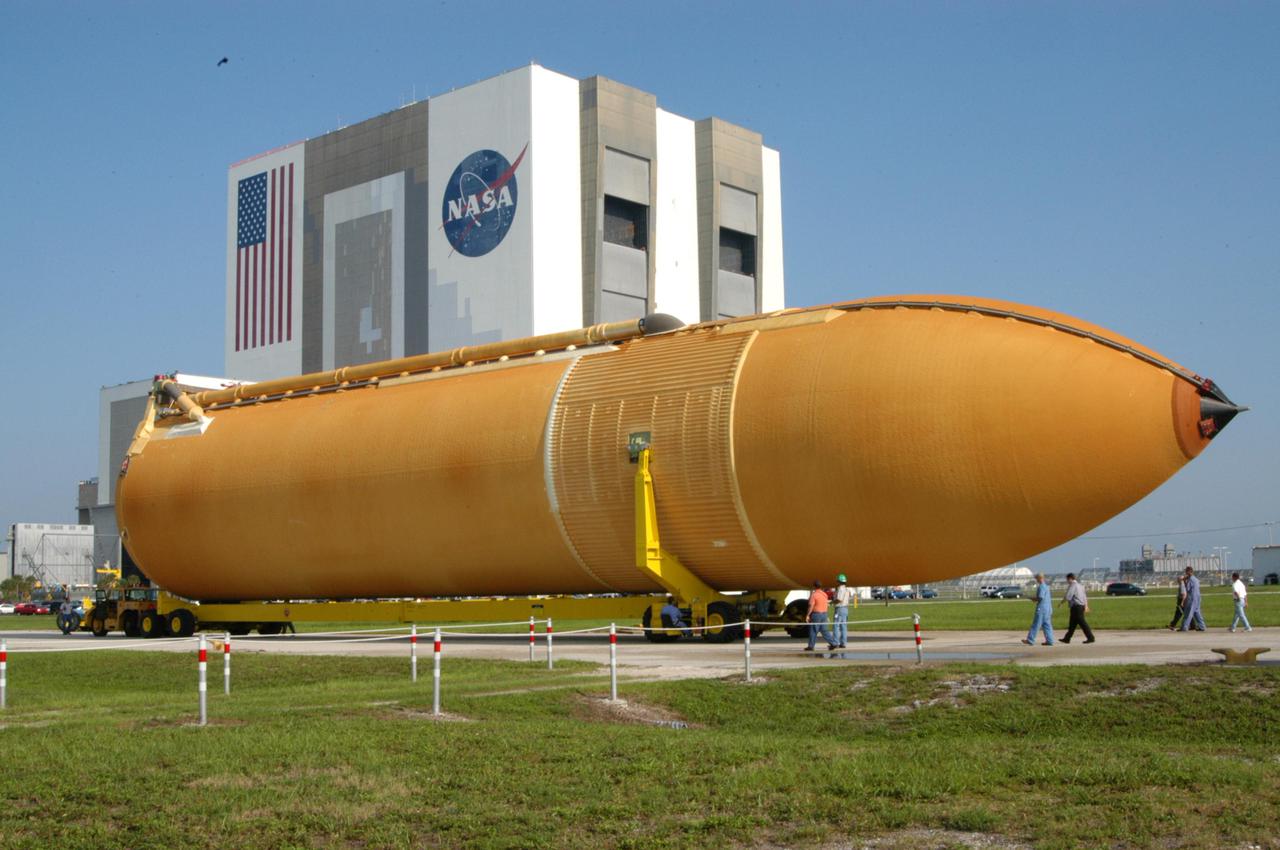 KENNEDY SPACE CENTER, FLA. - A newly redesigned External Tank (ET-119) moves slowly on the road leading from the Turn Basin in Launch Complex 39 Area at Kennedy Space Center, Florida.  The tank, which will be used on a future Space Shuttle launch, is being transported to the Vehicle Assembly Building, seen behind it.  The barge was towed on a 900-mile journey at sea from the Michoud Assembly Facility in New Orleans by one of NASA’s Solid Rocket Booster Retrieval Ships.
