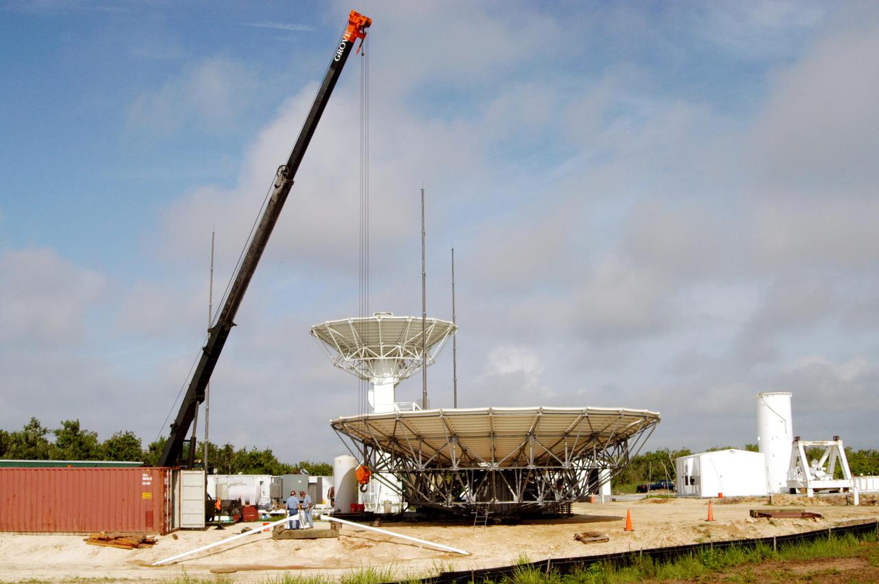 KENNEDY SPACE CENTER, FLA. - On June 6, progress is made in the erection of a C-band radar antenna at a radar site on North Merritt Island, Fla. The 50-foot C-band radar will be used for long-term Shuttle missions to track the launches and observe possible debris coming from the Shuttle. In the background is an existing 30-foot C-band Pathfinder radar whose use was demonstrated on the Delta Messenger launch. It will be used on the upcoming two Return to Flight missions. The launch window for the first Return to Flight mission, STS-114, is July 13 to July 31.