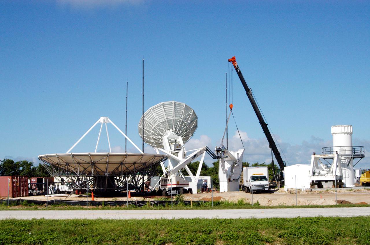 KENNEDY SPACE CENTER, FLA. - On June 14, work is underway on a radar site on North Merritt Island, Fla., constructing a C-band radar antenna (seen at left) and its base. The 50-foot C-band radar will be used for long-term Shuttle missions to track the launches and observe possible debris coming from the Shuttle. In the background (center) is an existing 30-foot C-band Pathfinder radar whose use was demonstrated on the Delta Messenger launch. It will be used on the upcoming two Return to Flight missions. The launch window for the first Return to Flight mission, STS-114, is July 13 to July 31.