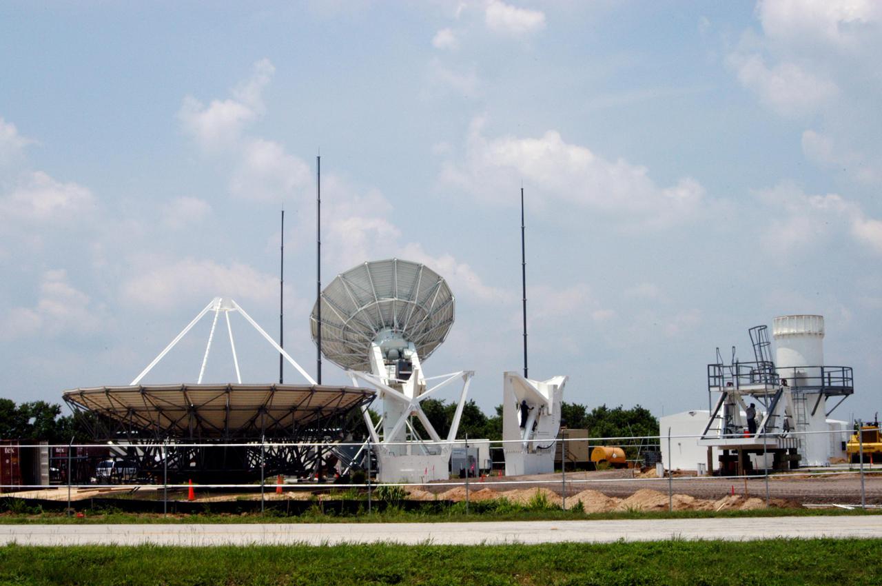KENNEDY SPACE CENTER, FLA. - On June 16, work is underway on a radar site on North Merritt Island, Fla., constructing a C-band radar antenna (seen at left) and its base. The 50-foot C-band radar will be used for long-term Shuttle missions to track the launches and observe possible debris coming from the Shuttle. In the background (center) is an existing 30-foot C-band Pathfinder radar whose use was demonstrated on the Delta Messenger launch. It will be used on the upcoming two Return to Flight missions. The launch window for the first Return to Flight mission, STS-114, is July 13 to July 31.