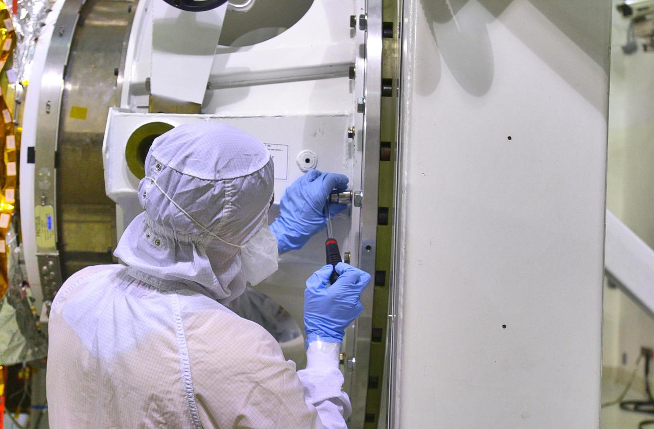 KENNEDY SPACE CENTER, FLA. - Inside the Astrotech Payload Processing Facility on Vandenberg Air Force Base in California, workers make adjustments on the tilt dolly before attempting to raise the Cloud-Aerosol Lidar and Infrared Pathfinder Satellite Observation (CALIPSO) spacecraft to vertical. CALIPSO will be moved to a workstand. It will undergo state-of-health checks, and electrical ground-support equipment testing. CALIPSO will fly in combination with the CloudSat satellite to provide never-before-seen 3-D perspectives of how clouds and aerosols form, evolve, and affect weather and climate. CALIPSO and CloudSat will join three other satellites in orbit to enhance understanding of climate systems. The launch date for CALIPSO_CloudSat is no earlier than Aug. 22.