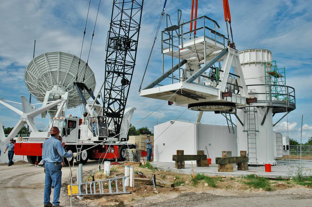 KENNEDY SPACE CENTER, FLA. - On a radar site on North Merritt Island, Fla., a crane lifts part of the structure to be added to the support base for a 50-foot C-band radar antenna.  The radar will be used for Shuttle missions to track the launches and observe possible debris coming from the Shuttle.   It will be used for the first time on STS-114. The launch window for the first Return to Flight mission is July 13 to July 31.