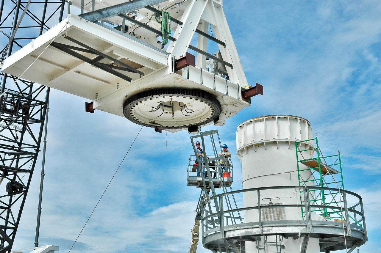 KENNEDY SPACE CENTER, FLA. - On a radar site on North Merritt Island, Fla., part of the structure to be added to the support base for a 50-foot C-band radar antenna is moved closer to the base. The radar will be used for Shuttle missions to track the launches and observe possible debris coming from the Shuttle.   It will be used for the first time on STS-114. The launch window for the first Return to Flight mission is July 13 to July 31.