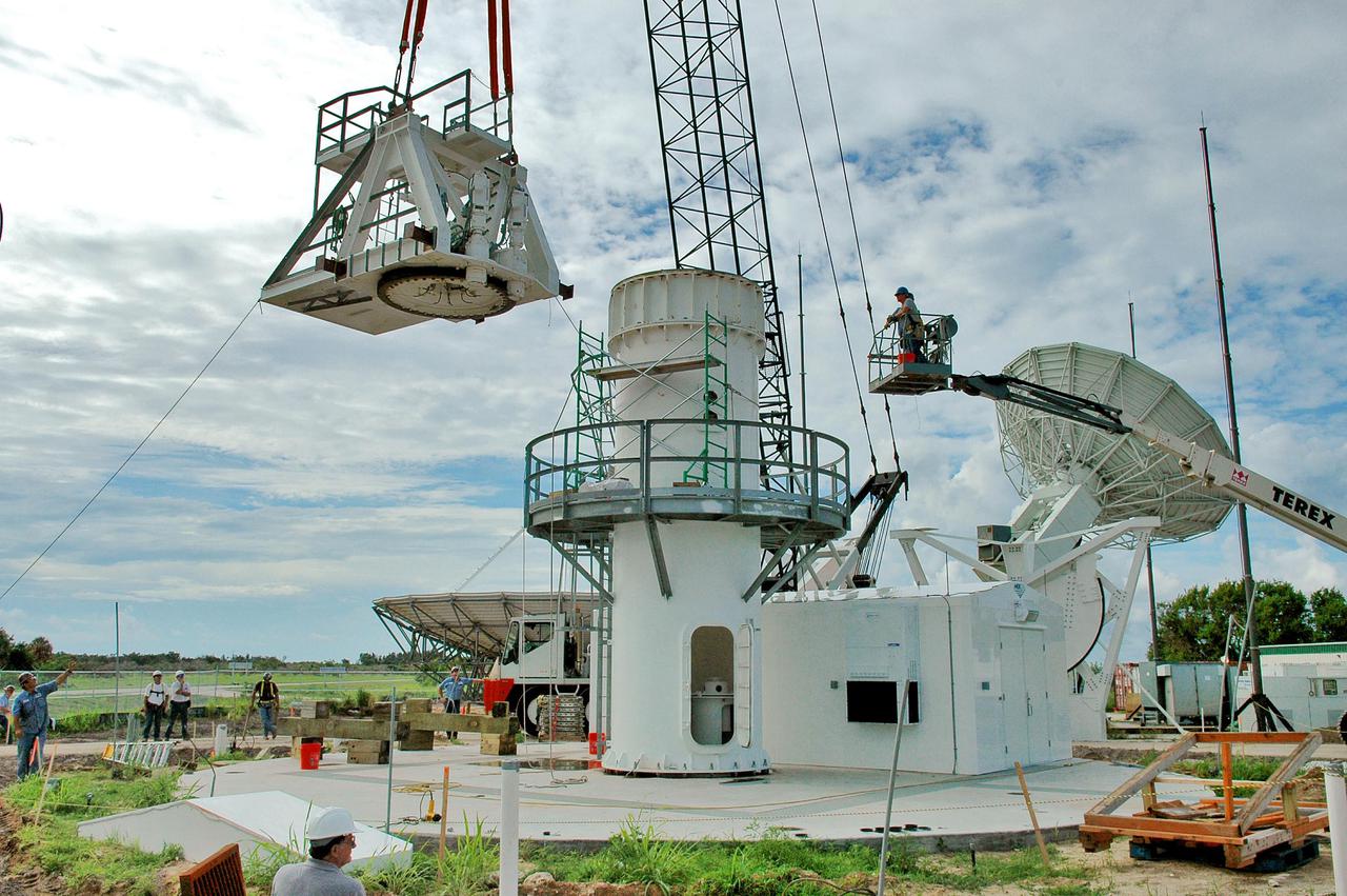 KENNEDY SPACE CENTER, FLA. - On a radar site on North Merritt Island, Fla., part of the structure for the support base for a 50-foot C-band radar antenna is put in position. The radar will be used for Shuttle missions to track the launches and observe possible debris coming from the Shuttle. It will be used for the first time on STS-114. The launch window for the first Return to Flight mission is July 13 to July 31.
