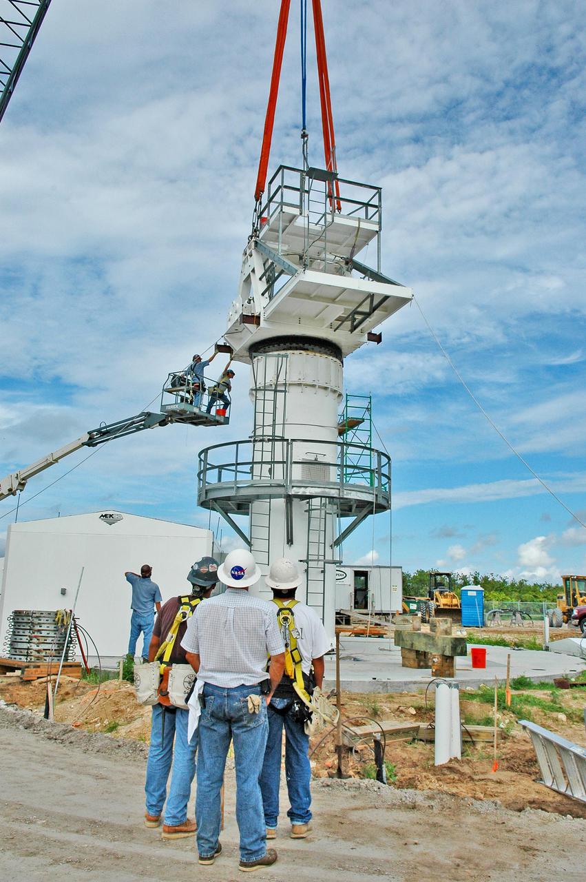 KENNEDY SPACE CENTER, FLA. - Workers start securing an upper section of the support base for a 50-foot C-band radar antenna being erected on a radar site on North Merritt Island, Fla.  The radar will be used for Shuttle missions to track the launches and observe possible debris coming from the Shuttle.   It will be used for the first time on STS-114. The launch window for the first Return to Flight mission is July 13 to July 31.