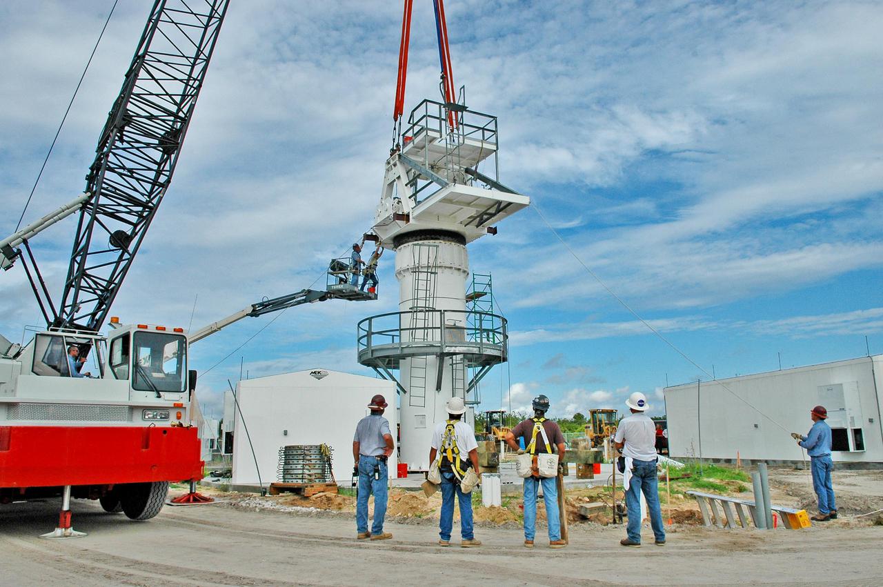 KENNEDY SPACE CENTER, FLA. - Workers secure an upper section of the support base for a 50-foot C-band radar antenna being erected on a radar site on North Merritt Island, Fla.  The radar will be used for Shuttle missions to track the launches and observe possible debris coming from the Shuttle.   It will be used for the first time on STS-114. The launch window for the first Return to Flight mission is July 13 to July 31.