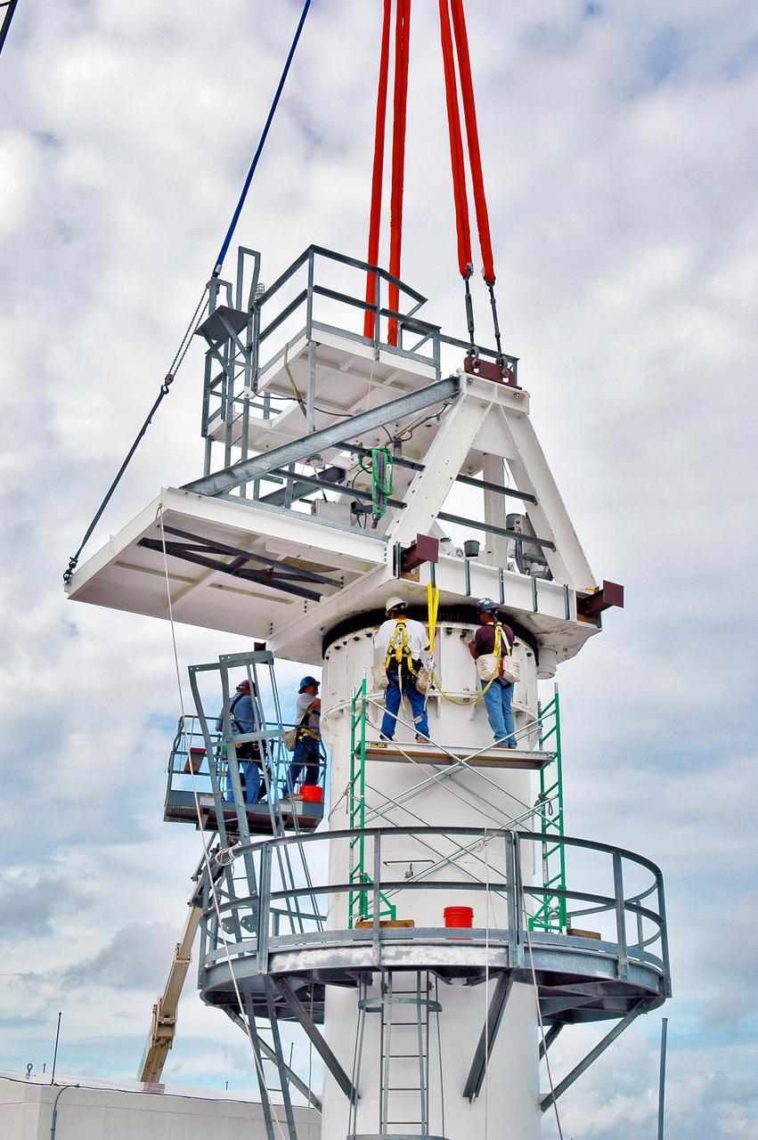 KENNEDY SPACE CENTER, FLA. - Workers secure an upper section of the support base for a 50-foot C-band radar antenna being erected on a radar site on North Merritt Island, Fla.   The radar will be used for Shuttle missions to track the launches and observe possible debris coming from the Shuttle.   It will be used for the first time on STS-114. The launch window for the first Return to Flight mission is July 13 to July 31.