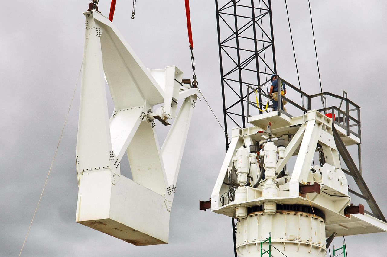 KENNEDY SPACE CENTER, FLA. - At a radar site on North Merritt Island, Fla., one of two counterweights is being lifted for installation on a support structure (right) for a 50-foot C-band radar antenna dish. The radar will be used for Shuttle missions to track the launches and observe possible debris coming from the Shuttle.  It will be used for the first time on STS-114. The launch window for the first Return to Flight mission is July 13 to July 31.