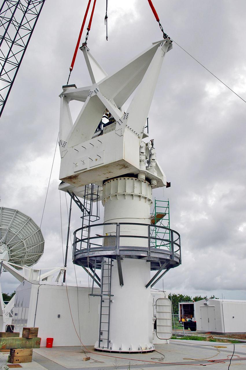 KENNEDY SPACE CENTER, FLA. - At a radar site on North Merritt Island, Fla., one of two counterweights is lifted into place on a support structure for a 50-foot C-band radar antenna dish. The radar will be used for Shuttle missions to track the launches and observe possible debris coming from the Shuttle. It will be used for the first time on STS-114. The launch window for the first Return to Flight mission is July 13 to July 31.
