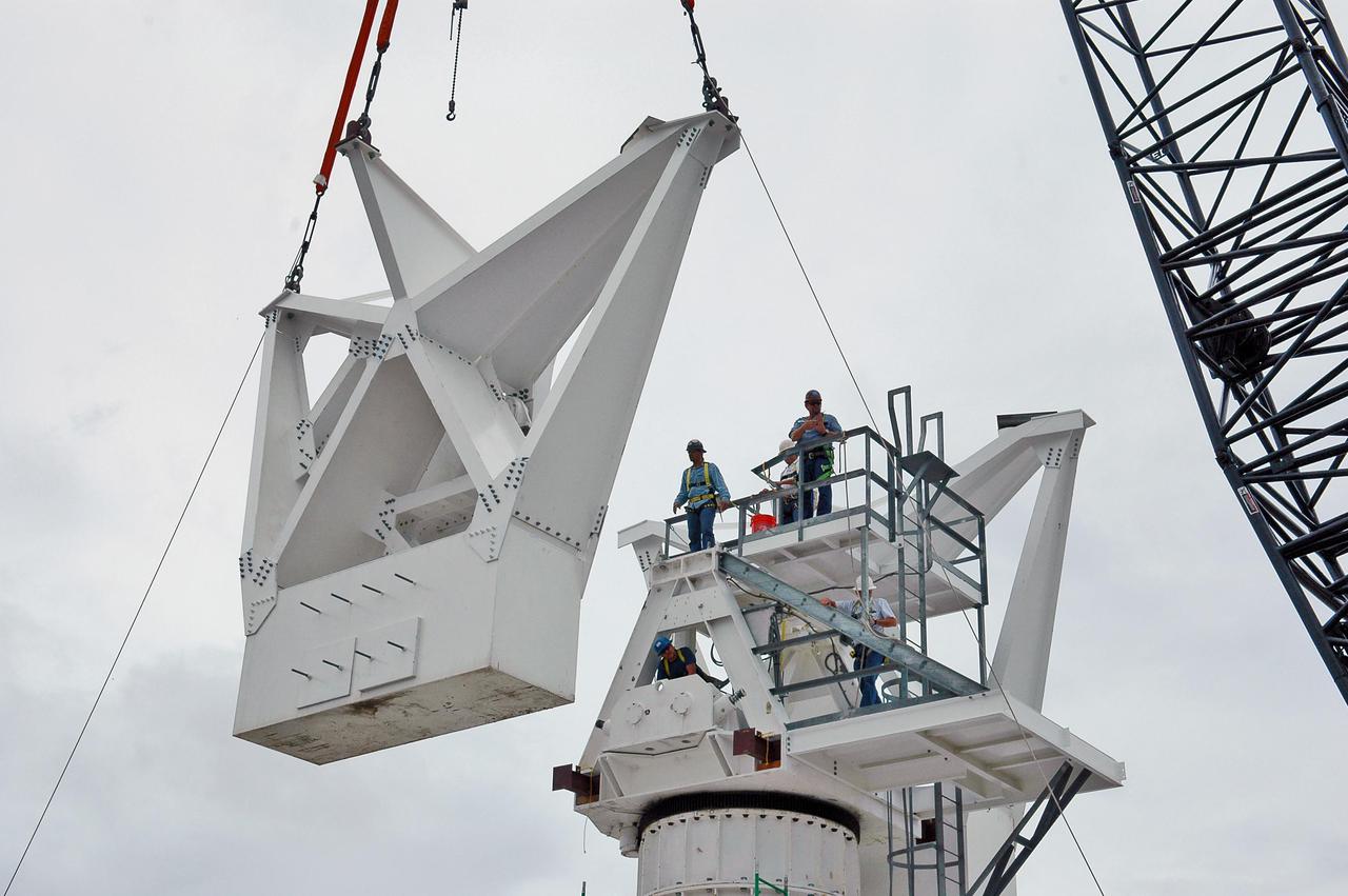 KENNEDY SPACE CENTER, FLA. - At a radar site on North Merritt Island, Fla., the second counterweight is being lifted for installation on the support structure (right) for a 50-foot C-band radar antenna dish. The radar will be used for Shuttle missions to track the launches and observe possible debris coming from the Shuttle.  It will be used for the first time on STS-114. The launch window for the first Return to Flight mission is July 13 to July 31.