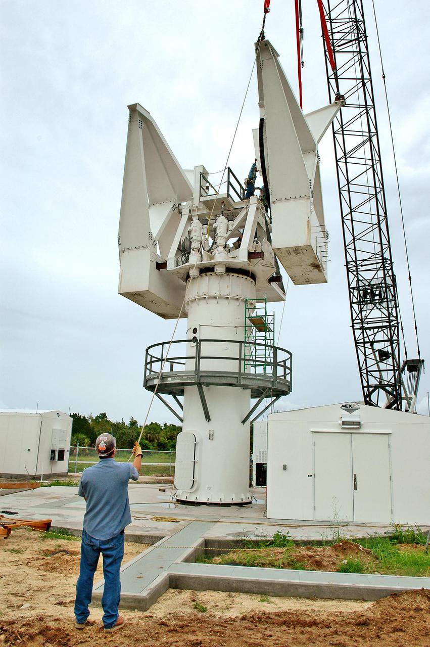 KENNEDY SPACE CENTER, FLA. - At a radar site on North Merritt Island, Fla., the second counterweight (right side) is lifted into place on the support structure for a 50-foot C-band radar antenna dish. The radar will be used for Shuttle missions to track the launches and observe possible debris coming from the Shuttle.  It will be used for the first time on STS-114. The launch window for the first Return to Flight mission is July 13 to July 31.