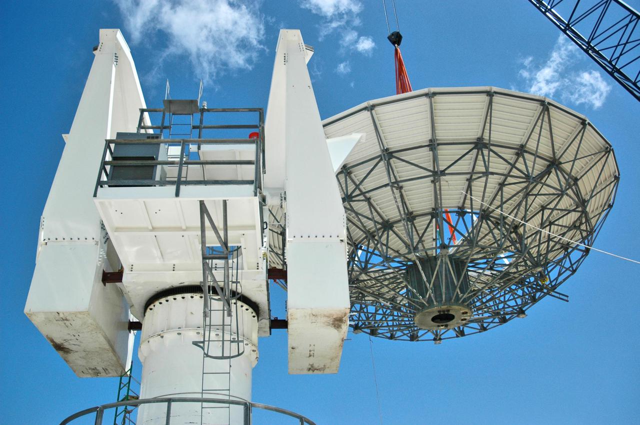 KENNEDY SPACE CENTER, FLA. - At a radar site on North Merritt Island, Fla., the 50-foot C-band radar antenna dish is lifted above the support structure, where it will be installed on top. The radar will be used for Shuttle missions to track the launches and observe possible debris coming from the Shuttle. It will be used for the first time on STS-114. The launch window for the first Return to Flight mission is July 13 to July 31.