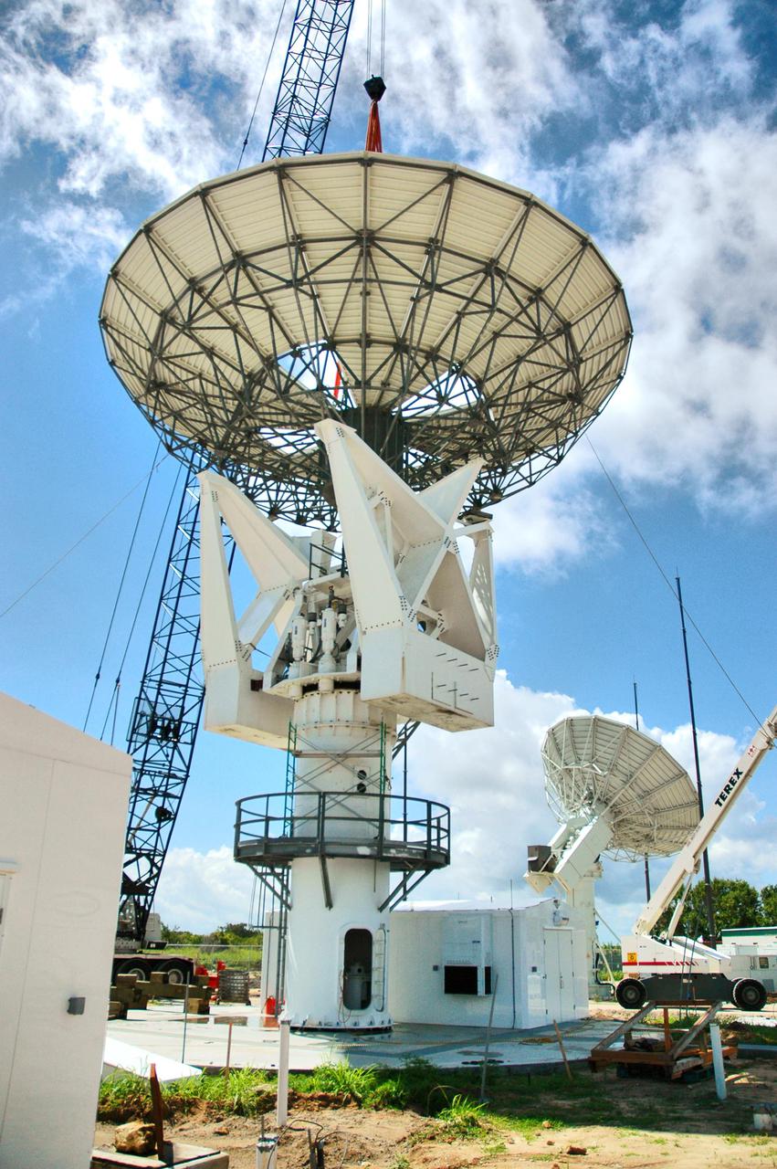 KENNEDY SPACE CENTER, FLA. - At a radar site on North Merritt Island, Fla., the 50-foot C-band radar antenna dish is lowered toward the top of the support structure.  It will be placed on the counterweights installed there.   The radar will be used for Shuttle missions to track the launches and observe possible debris coming from the Shuttle.  It will be used for the first time on STS-114. The launch window for the first Return to Flight mission is July 13 to July 31.