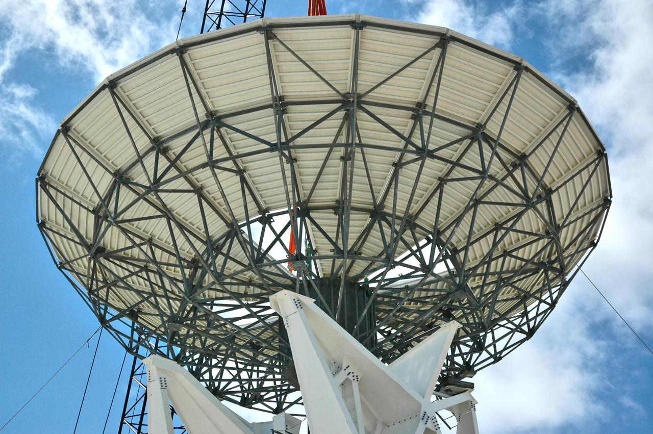 KENNEDY SPACE CENTER, FLA. - At a radar site on North Merritt Island, Fla., the 50-foot C-band radar antenna dish is lowered toward the top of the support structure.  It will be placed on the counterweights installed there.  The radar will be used for Shuttle missions to track the launches and observe possible debris coming from the Shuttle.  It will be used for the first time on STS-114. The launch window for the first Return to Flight mission is July 13 to July 31.
