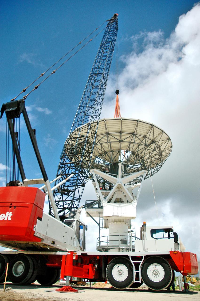 KENNEDY SPACE CENTER, FLA. - At a radar site on North Merritt Island, Fla., the 50-foot C-band radar antenna dish is lowered toward the top of the support structure. It will be placed on the counterweights installed there. The radar will be used for Shuttle missions to track the launches and observe possible debris coming from the Shuttle. It will be used for the first time on STS-114. The launch window for the first Return to Flight mission is July 13 to July 31.
