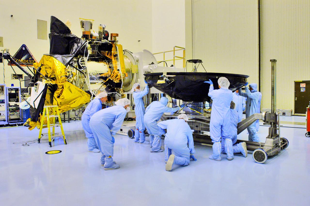 KENNEDY SPACE CENTER, FLA. - In the Payload Hazardous Servicing Facility at NASA’s Kennedy Space Center, workers from Lockheed Martin prepare the high-gain antenna for installation on the Mars Reconnaissance Orbiter (MRO), in the background. After solar array installation, the MRO will be transported to the Vertical Installation Facility in late July. It will join the Atlas V for the final phase of launch preparations. The spacecraft is then scheduled to undergo a functional test, and a final week of integrated testing and closeouts. The MRO was built by Lockheed Martin for the Jet Propulsion Laboratory in California. It is the next major step in Mars exploration and scheduled for launch from Cape Canaveral Air Force Station in a window opening Aug. 10. The MRO is an important next step in fulfilling NASA’s vision of space exploration and ultimately sending human explorers to Mars and beyond.