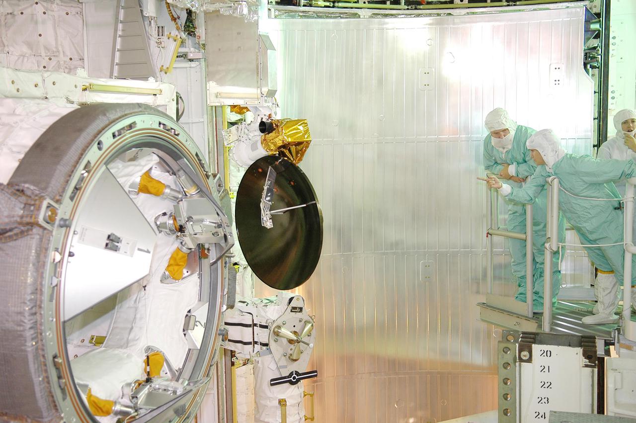 KENNEDY SPACE CENTER, FLA. - At Launch Pad 39B, STS-114 Commander Eileen Collins (leaning forward) discusses the payloads in Space Shuttle Discovery's cargo bay with Mission Specialist Wendy Lawrence (right) looking on behind her. The STS-114 crew is conducting a final inspection of their mission payloads before launch. During its 12-day mission, Discovery’s seven-person crew will test new hardware and techniques to improve Shuttle safety, as well as deliver supplies to the International Space Station. Discovery’s payloads include the Multi-Purpose Logistics Module Raffaello, the Lightweight Multi-Purpose Experiment Support Structure Carrier (LMC), and the External Stowage Platform-2 (ESP-2). Raffaello will deliver supplies to the International Space Station including food, clothing and research equipment. The LMC will carry a replacement Control Moment Gyroscope and a tile repair sample box. The ESP-2 is outfitted with replacement parts. Launch of Discovery on its Return to Flight mission STS-114 is set for July 13.