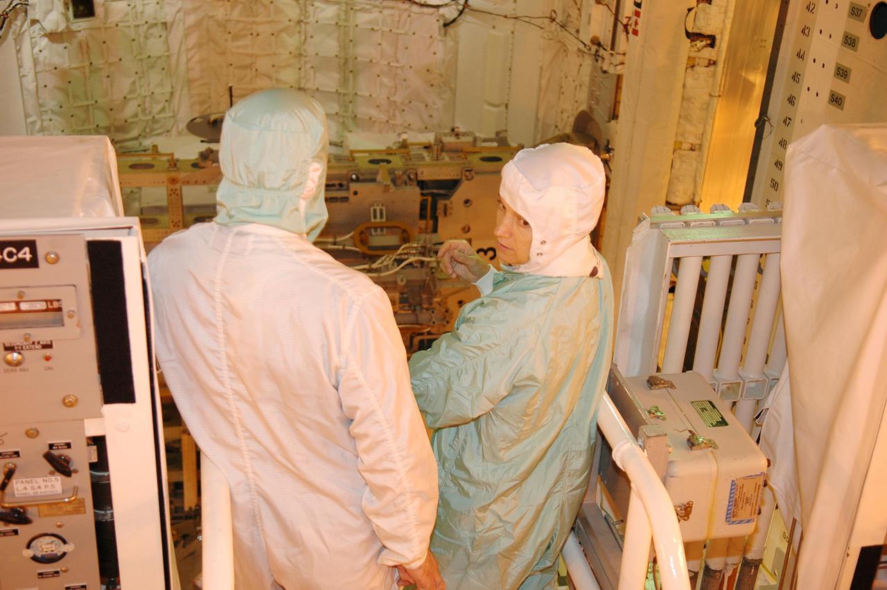 KENNEDY SPACE CENTER, FLA. - At Launch Pad 39B, STS-114 Commander Eileen Collins (right) takes a final look at the payloads in Space Shuttle Discovery's cargo bay before launch. During its 12-day mission, Discovery’s seven-person crew will test new hardware and techniques to improve Shuttle safety, as well as deliver supplies to the International Space Station. Discovery’s payloads include the Multi-Purpose Logistics Module Raffaello, the Lightweight Multi-Purpose Experiment Support Structure Carrier (LMC), and the External Stowage Platform-2 (ESP-2). Raffaello will deliver supplies to the International Space Station including food, clothing and research equipment. The LMC will carry a replacement Control Moment Gyroscope and a tile repair sample box. The ESP-2 is outfitted with replacement parts. Launch of Discovery on its Return to Flight mission STS-114 is set for July 13.