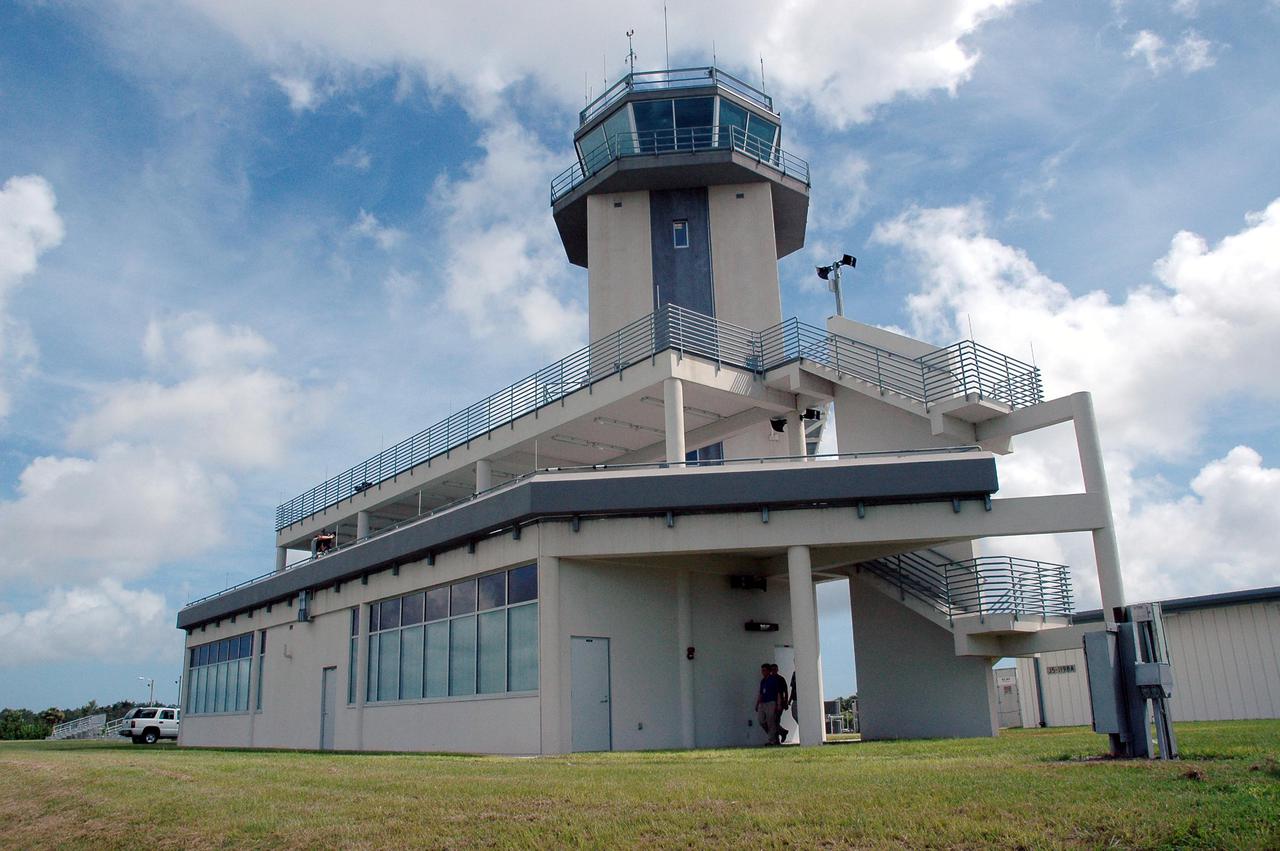 KENNEDY SPACE CENTER, FLA. - At the Shuttle Landing Facility on NASA’s Kennedy Space Center, this new media building features a new Air Traffic Control Tower.  The facility was dedicated in a ribbon-cutting ceremony July 8 that included Center Director Jim Kennedy, Space Gateway Support President William A. Sample, External Relations Director Lisa Malone, Center Operations Director Scott D. Kerr, and KSC Safety Aviation Officer Albert E. Taff.  The facility was built for the Return to Flight mission STS-114 and the landing of Shuttle Discovery.  The structure rises 110 feet over the midpoint of the runway and offers air traffic controllers a magnificent 360-degree view of Kennedy Space Center, Cape Canaveral Air Force Station and north Brevard County. It replaces the small, portable tower installed at the edge of the runway in 1986. The new control tower will manage all landings and departures from the SLF, including air traffic within the Kennedy Space Center-Cape Canaveral restricted airspace.  The facility provides a 24-hour weather-observing facility providing official hourly weather observations for the SLF and the Cape Canaveral vicinity, including special observations for all launches and landings. State-of-the-art, weather-observing equipment has been installed for Space Shuttle landings and for serving conventional aircraft landing at the SLF. At this location, weather observers will have a multi-directional view of the weather conditions at the runway and Launch Complex 39.