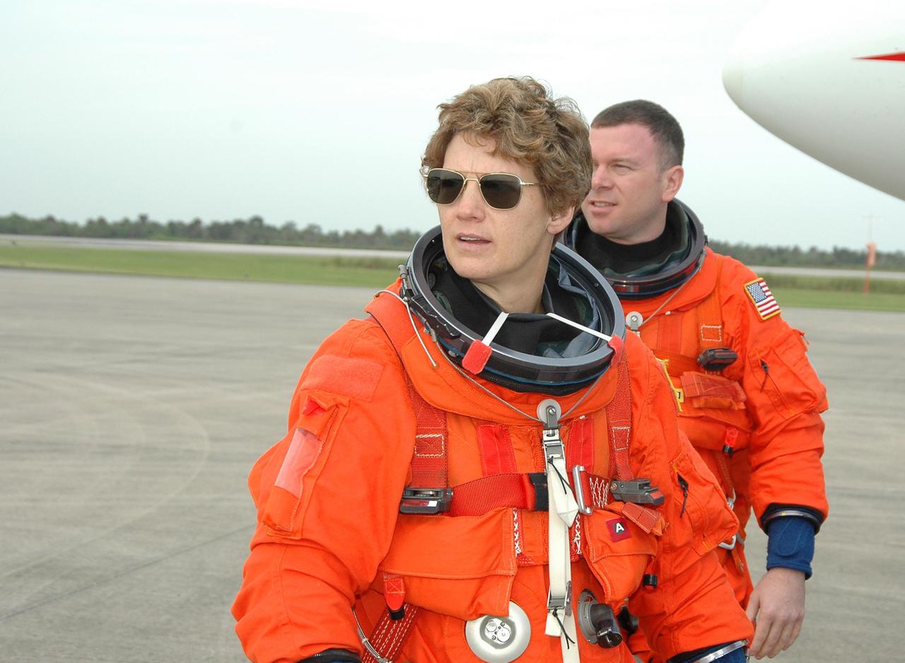KENNEDY SPACE CENTER, FLA. -- Eileen Collins, mission commander on Return to Flight STS-114, and Pilot James Kelly walk away from the Shuttle Training Aircraft (STA) at the Shuttle Landing Facility on NASA’s Kennedy Space Center. They are practicing landing the orbiter using the STA, which is a modified Grumman American Aviation-built Gulf Stream II executive jet that was modified to simulate an orbiter’s cockpit, motion and visual cues, and handling qualities.   In flight, the STA duplicates the orbiter’s atmospheric descent trajectory from approximately 35,000 feet altitude to landing on a runway. Because the orbiter is unpowered during re-entry and landing, its high-speed glide must be perfectly executed the first time.  Mission STS-114 is scheduled to launch aboard Space Shuttle Discovery with a crew of seven on July 13 at 3:51 p.m. from Launch Pad 39B.