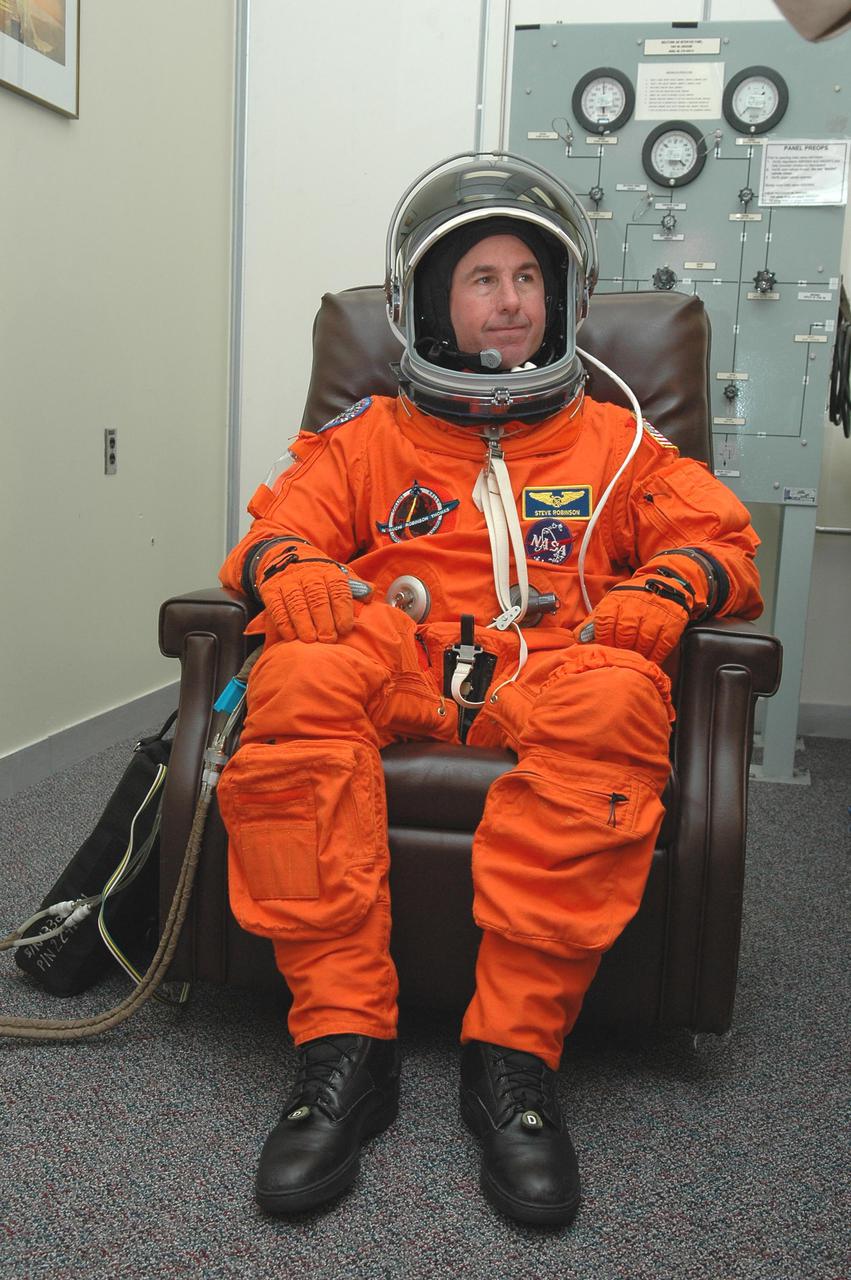 KENNEDY SPACE CENTER, FLA. -- In the Operations and Checkout Building at NASA’s Kennedy Space Center, Return to Flight STS-114 Mission Specialist Stephen Robinson checks the fit of his launch and entry suit and helmet. This is Robinson’s third Shuttle launch. There are two days to the launch of Space Shuttle Discovery scheduled for 3:51 p.m. July 13. This launch is the 114th Space Shuttle flight and is scheduled to last about 12 days with a planned KSC landing at about 11:06 a.m. EDT on July 25.