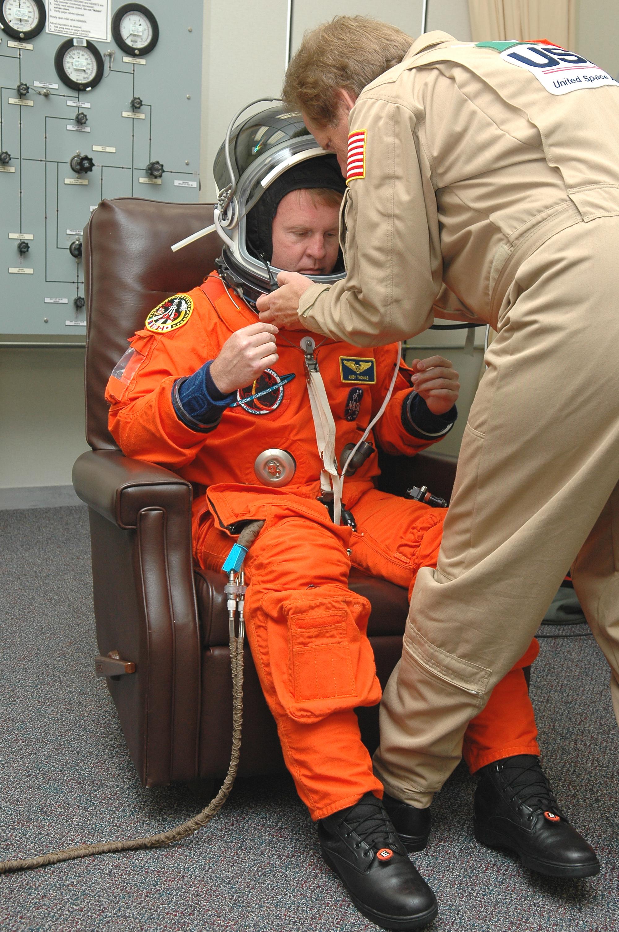 KENNEDY SPACE CENTER, FLA. -- In the Operations and Checkout Building at NASA’s Kennedy Space Center, Return to Flight STS-114 Mission Specialist Andrew Thomas checks the fit of his helmet, as well as his launch and entry suit. This is Thomas’ fourth Shuttle flight. There are two days to the launch of Space Shuttle Discovery scheduled for 3:51 p.m. July 13. This launch is the 114th Space Shuttle flight and is scheduled to last about 12 days with a planned KSC landing at about 11:06 a.m. EDT on July 25.