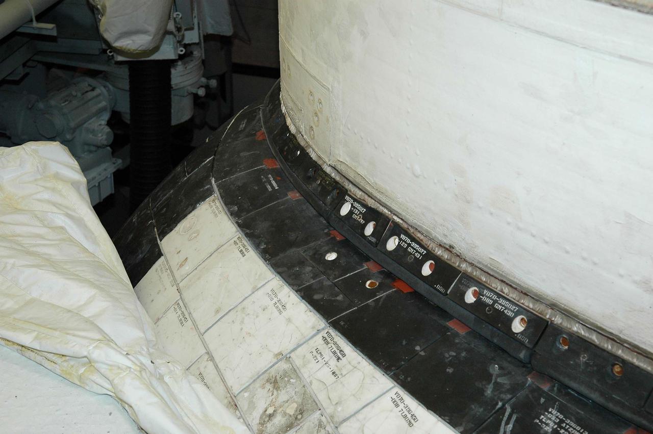 KENNEDY SPACE CENTER, FLA. - This view shows the carrier panel on the left Orbital Maneuvering System (OMS) pod on Space Shuttle Discovery. During routine closeouts at Launch Pad 39B, the cover of Discovery’s window number seven, one of the overhead crew cabin windows, fell about 65 feet and hit a carrier panel on the OMS pod, damaging several tiles. The tiles were on a single carrier panel, which fits over the area. A spare carrier panel was taken to the pad and used to replace the damaged panel. The replacement procedure took about an hour to complete. There was no delay to the launch countdown.
