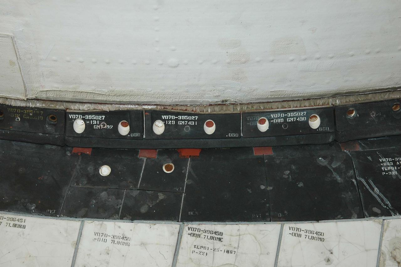 KENNEDY SPACE CENTER, FLA. - This view shows the carrier panel on the left Orbital Maneuvering System (OMS) pod on Space Shuttle Discovery. During routine closeouts at Launch Pad 39B, the cover of Discovery’s window number seven, one of the overhead crew cabin windows, fell about 65 feet and hit a carrier panel on the OMS pod, damaging several tiles. The tiles were on a single carrier panel, which fits over the area. A spare carrier panel was taken to the pad and used to replace the damaged panel. The replacement procedure took about an hour to complete. There was no delay to the launch countdown.