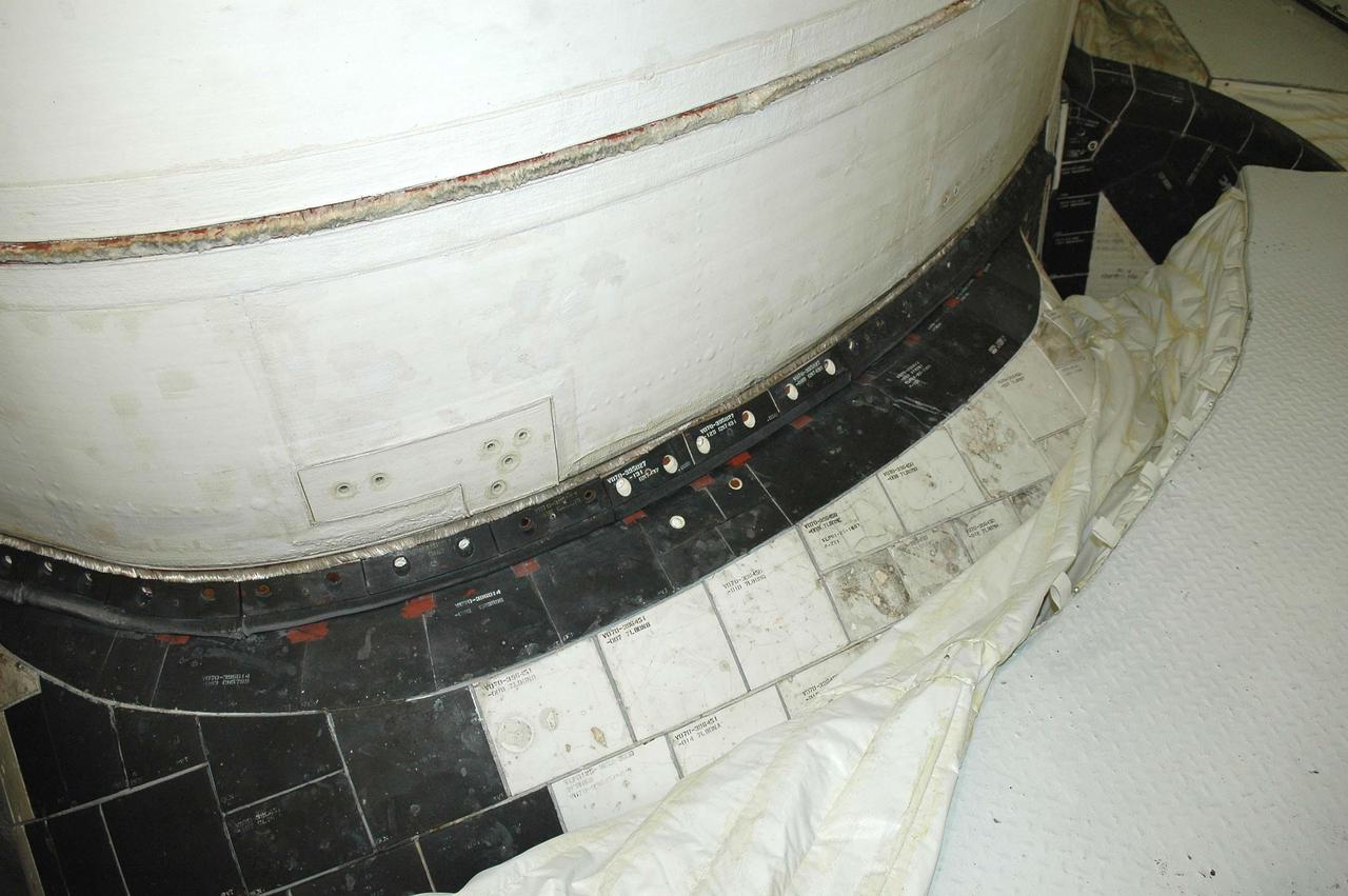 KENNEDY SPACE CENTER, FLA. - This view shows the carrier panel on the left Orbital Maneuvering System (OMS) pod on Space Shuttle Discovery. During routine closeouts at Launch Pad 39B, the cover of Discovery’s window number seven, one of the overhead crew cabin windows, fell about 65 feet and hit a carrier panel on the OMS pod, damaging several tiles. The tiles were on a single carrier panel, which fits over the area. A spare carrier panel was taken to the pad and used to replace the damaged panel. The replacement procedure took about an hour to complete. There was no delay to the launch countdown.