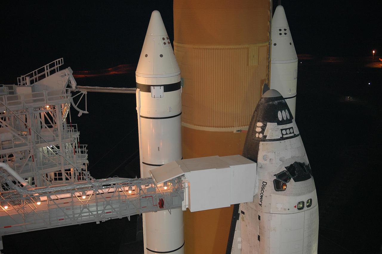 KENNEDY SPACE CENTER, FLA. -  Following rollback of the Rotating Service Structure, the orbiter access arm is able to be extended to Space Shuttle Discovery.  The arm provides access into Discovery through the White Room, where the astronauts are checked by the closeout crew.  Behind Discovery is the orange External Tank, flanked by the twin white Solid Rocket Boosters.  Discovery is scheduled to launch on the historic Return to Flight mission STS-114 at 3:51 p.m. July 13 with a crew of seven.  The payload includes the External Stowage Platform-2, equipped with spare part assemblies, and a replacement Control Moment Gyroscope contained in the Lightweight Multi-Purpose Experiment Support Structure.  The astronauts will make three spacewalks, including one to practice repair techniques for the Shuttle’s heat shield and one to install the new gyroscope. This is the 114th Space Shuttle flight and the 31st for Discovery.  The 12-day mission is expected to end with touchdown at NASA Kennedy Space Center’s Shuttle Landing Facility at 11:06 a.m. July 25.
