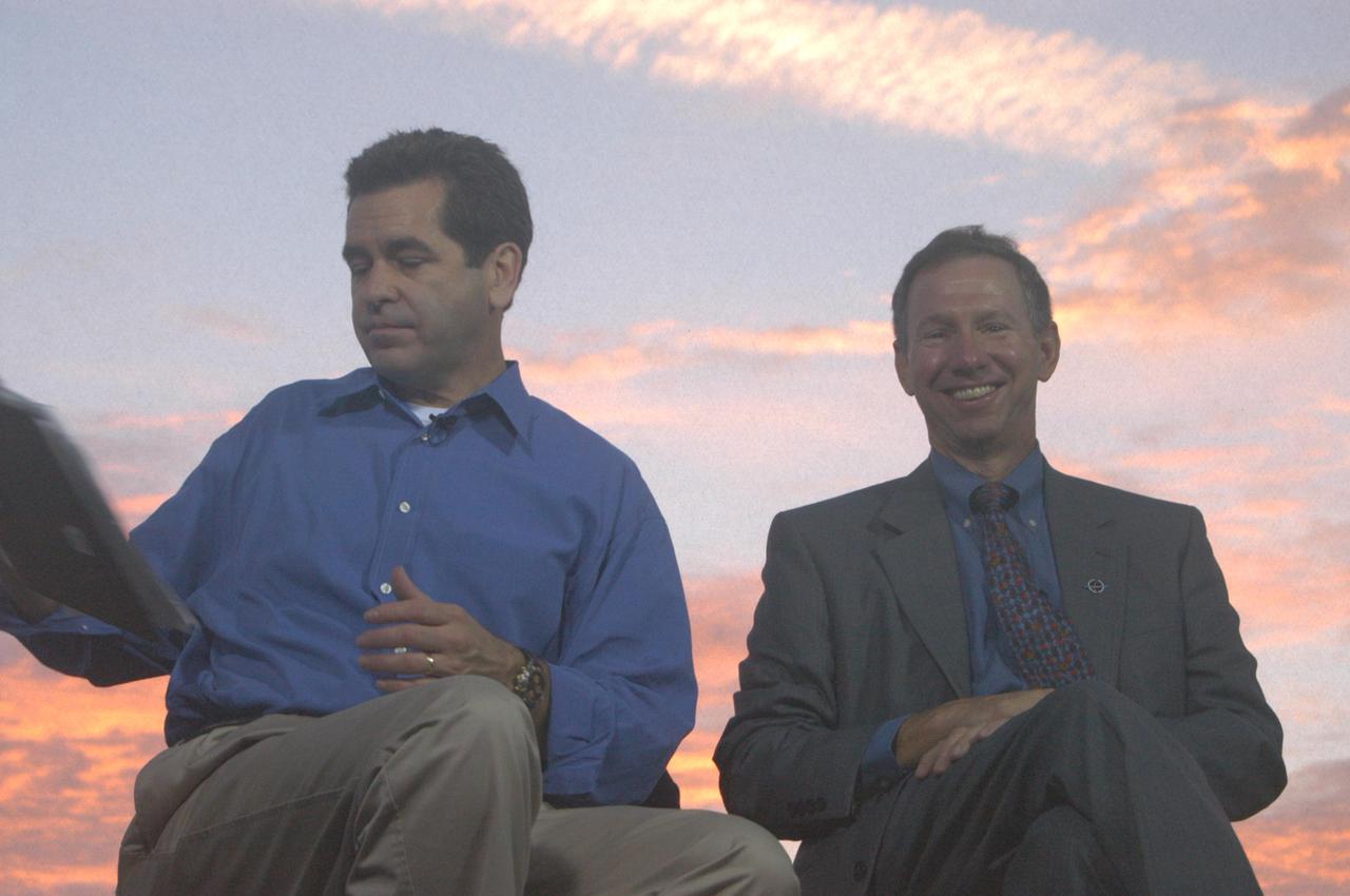 KENNEDY SPACE CENTER, FLA. -   Against a sunrise-painted sky at NASA Kennedy Space Center, Miles O’Brien (left), co-anchor on CNN’s American Morning, checks his notes during a talk on air with NASA Administrator Mike Griffin about the pending 3:51 p.m. launch of Space Shuttle Discovery on the historic Return to Flight mission STS-114.  It is the 114th Space Shuttle flight and the 31st for Discovery.  The 12-day mission is expected to end with touchdown at the Shuttle Landing Facility at 11:06 a.m. July 25.