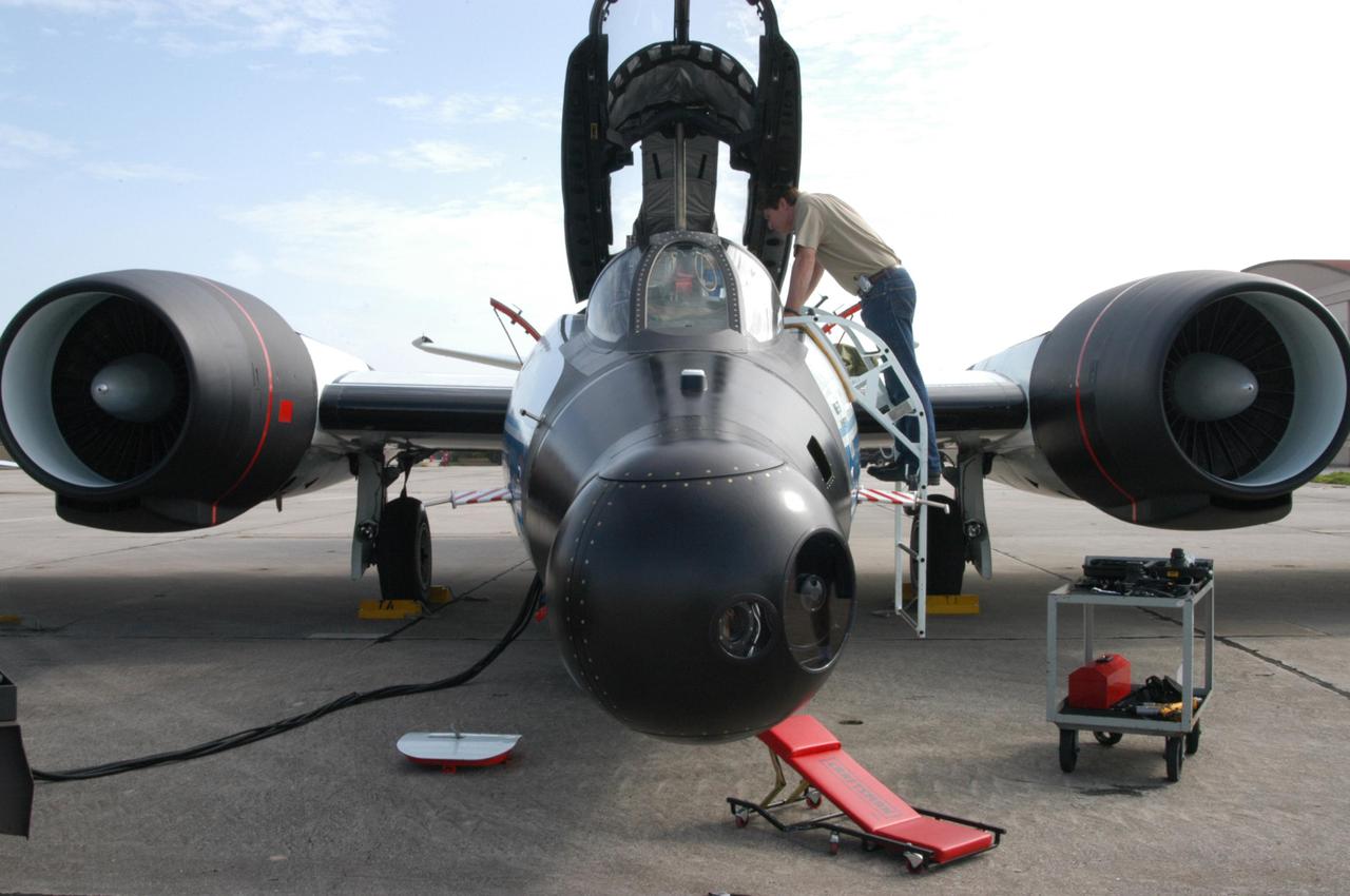 KENNEDY SPACE CENTER, FLA. -   At Patrick Air Force Base in Cocoa Beach, Fla., workers prepare the WB-57F aircraft that will take photos of Space Shuttle Discovery during its launch on Return to Flight mission STS-114.  NASA approved the development and implementation of the aircraft-based imaging system, known as the WB-57 Ascent Video Experiment (WAVE).  The WAVE provides both ascent and entry imagery and enables better observation of the Shuttle on days of heavier cloud cover and areas obscured from ground cameras by the launch exhaust plume. WAVE comprises a 32-inch-ball turret system mounted on the nose of two WB-57 aircraft. The turret houses an optical bench, providing installation of both HDTV and infrared cameras. Optics consist of an 11-inch-diameter, 4.2 meter fixed-focal-length lens. The system can be operated in both auto track and manual modes.